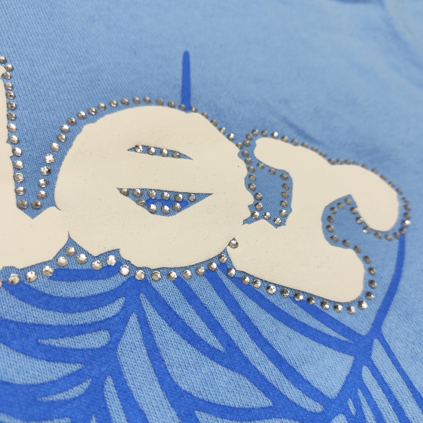 Full puff-print artwork on Sp5der Web Hoodie Sky Blue with white logo and signature blue spider web
Close-up of white puff-print Sp5der lettering and rhinestone edge details on Sky Blue Hoodie
Side angle showing the raised three-dimensional puff logo and rhinestone trim on Sp5der Sky Blue Hoodie