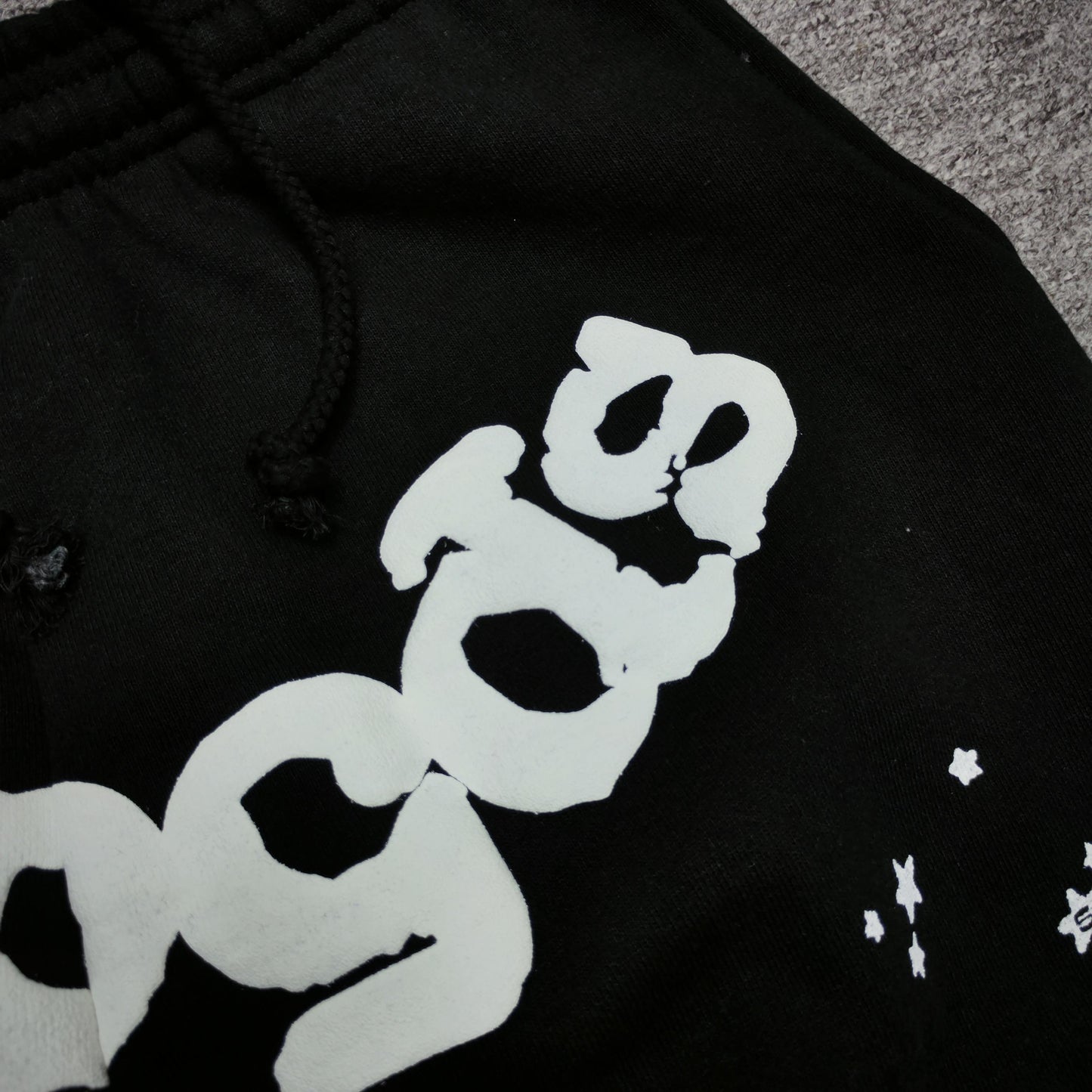 Close-up of defined puff-print edges on SP5DER OG Web sweatpants