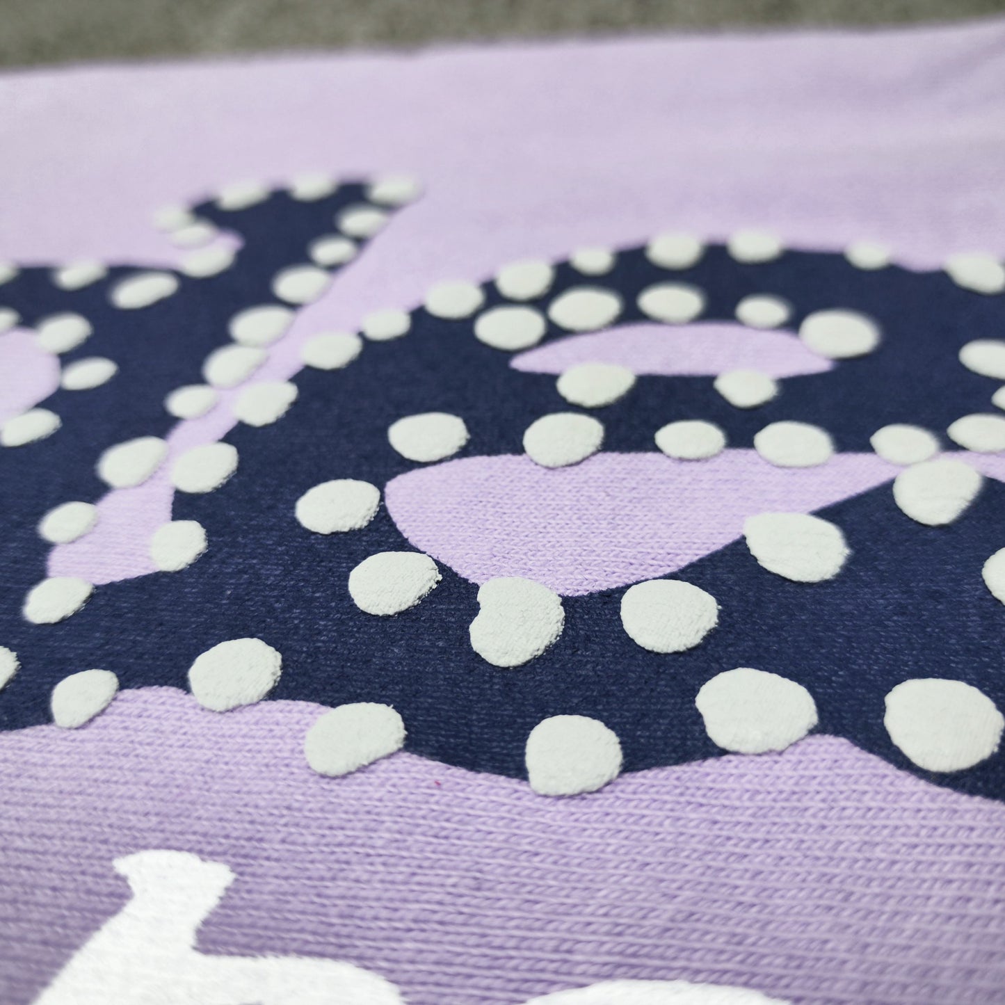 Raised navy puff-print texture on SP5DER Acai purple sweatpants
White dot detailing around the navy SP5DER graphic on Acai sweatpants
White slogan print detail on SP5DER Acai purple sweatpants
