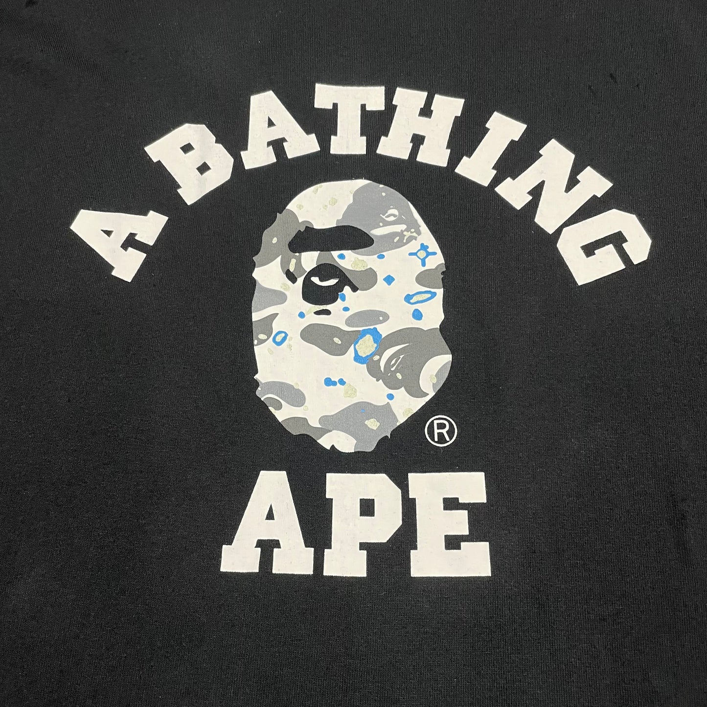 White and grey Space Camo College graphic on black BAPE T-shirt
Close-up of white Space Camo Ape Head graphic on black BAPE T-shirt
Detailed grey white and blue Space Camo pattern on black BAPE T-shirt