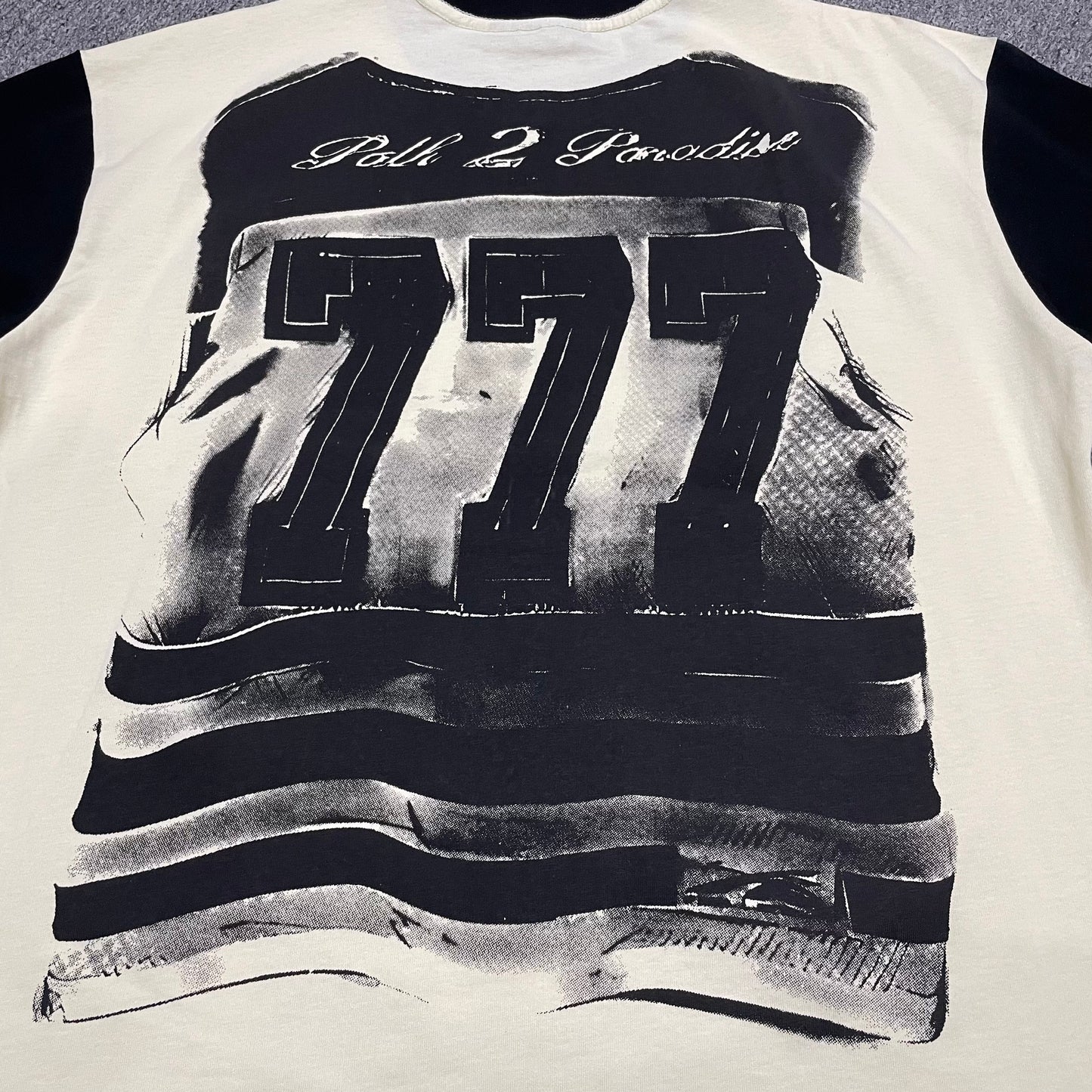Full back graphic artwork on the Cream and Black Hellstar Helmet Tee
Close-up of the rear graphic print on the Hellstar Helmet T-Shirt
Detailed view of the distressed rear artwork on the Hellstar Helmet graphic T-shirt