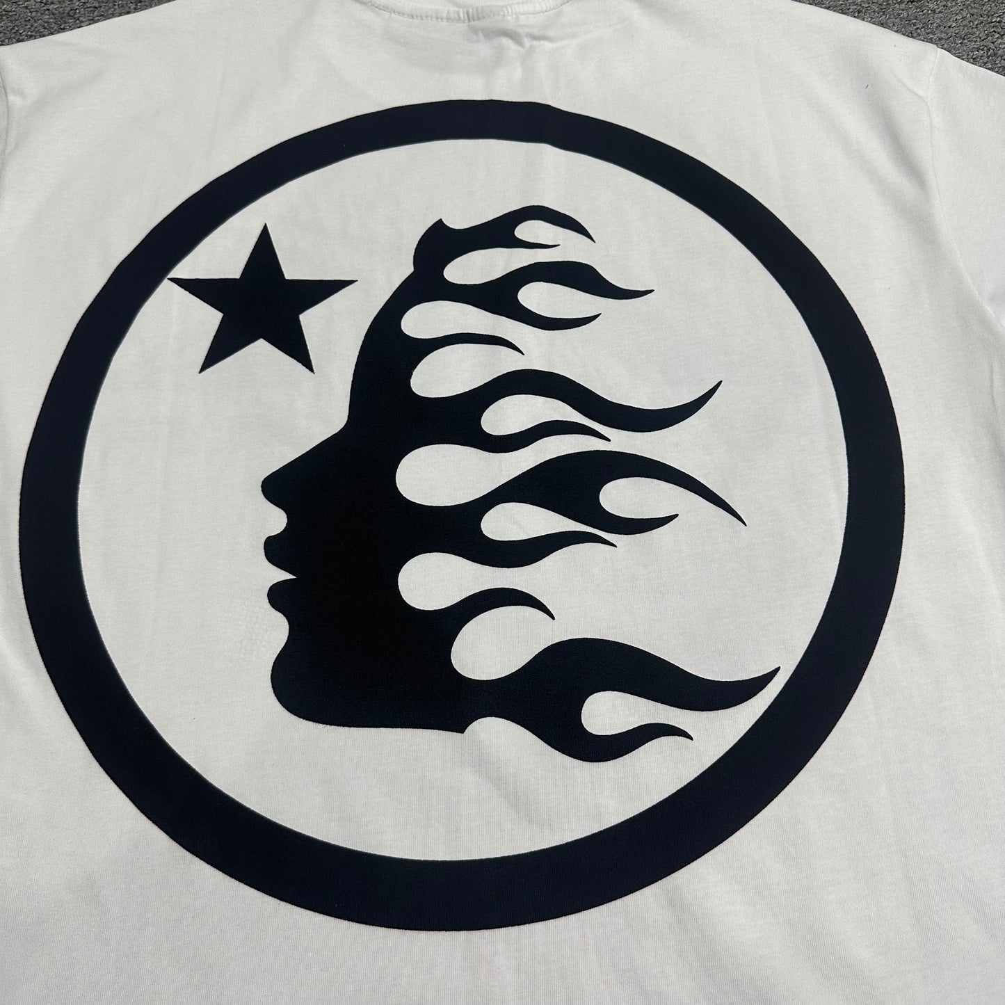 Full black Hellstar classic logo graphic on white rhinestone T-shirt
Full rhinestone decoration surrounding the Hellstar logo on white T-shirt
Detailed crystal placement around the Hellstar logo graphic
Black Hellstar classic logo graphic detail on white T-shirt