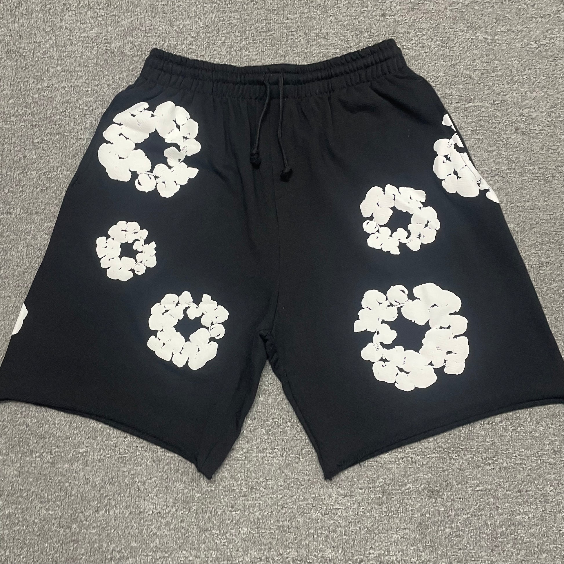 Black Cotton Wreath Sweatshorts with all-over white puff print
Close-up of white Cotton Wreath puff print on Black sweatshorts
Raised 3D Cotton Wreath puff print texture on Black sweatshorts