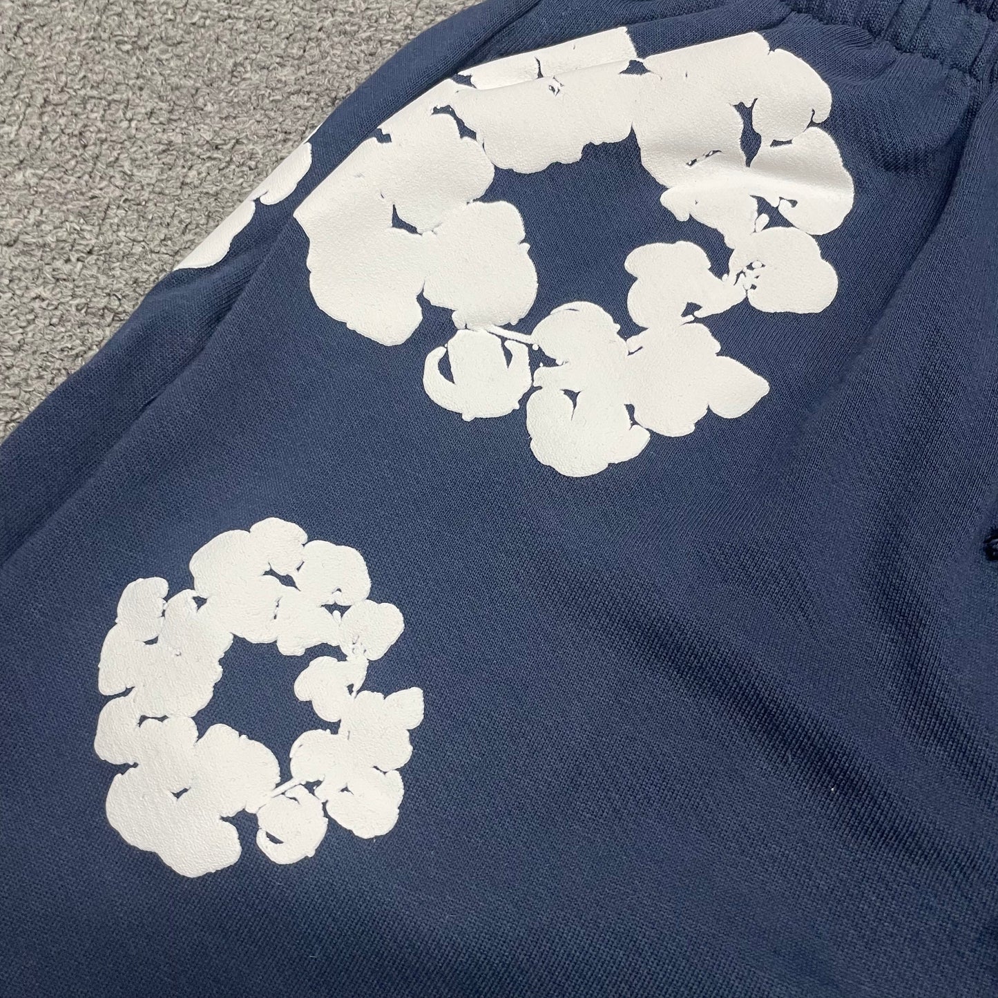 Navy Cotton Wreath Sweatshorts with all-over white puff print
Close-up of white Cotton Wreath puff print on Navy sweatshorts
Raised 3D Cotton Wreath puff print texture on Navy sweatshorts