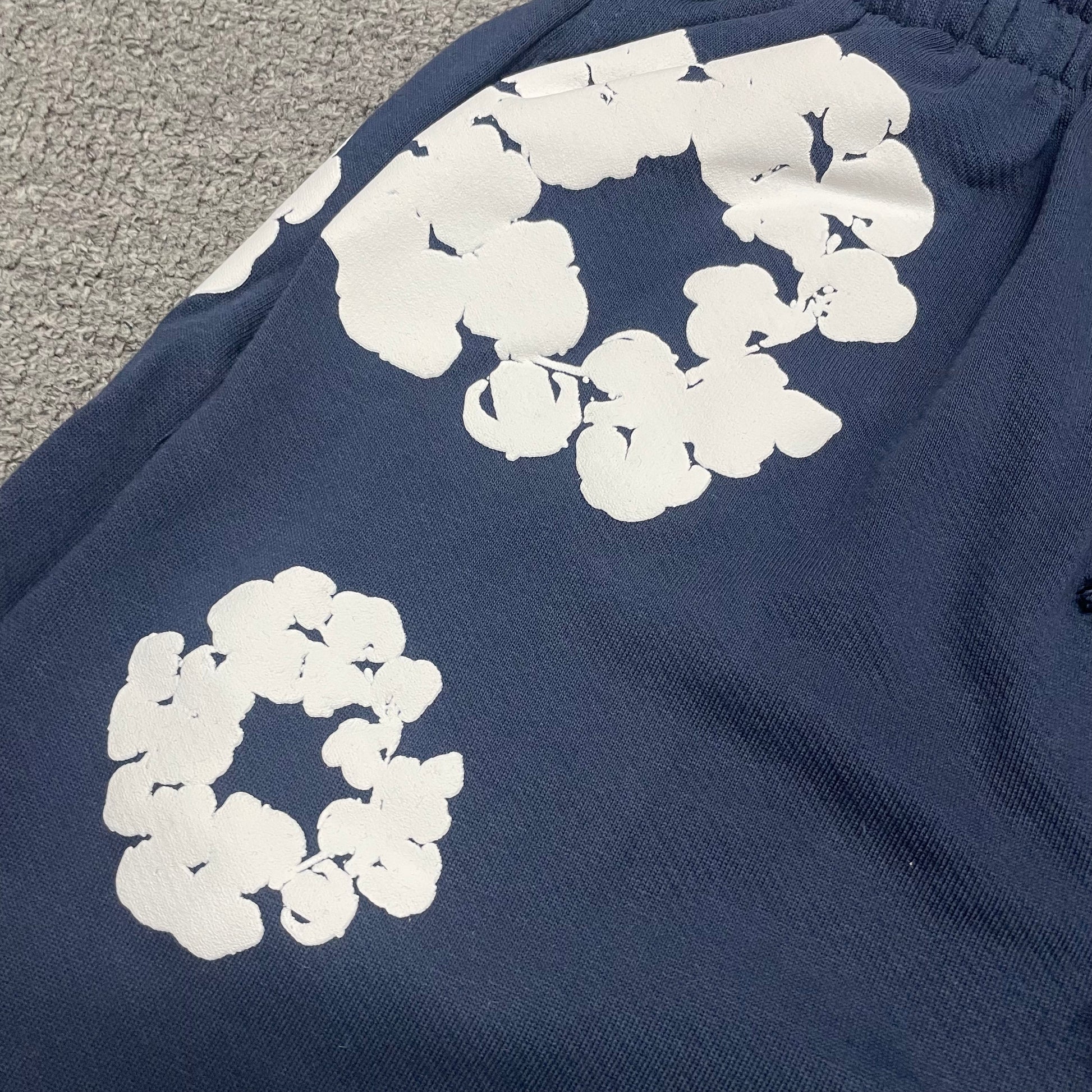 Navy Cotton Wreath Sweatshorts with all-over white puff print
Close-up of white Cotton Wreath puff print on Navy sweatshorts
Raised 3D Cotton Wreath puff print texture on Navy sweatshorts