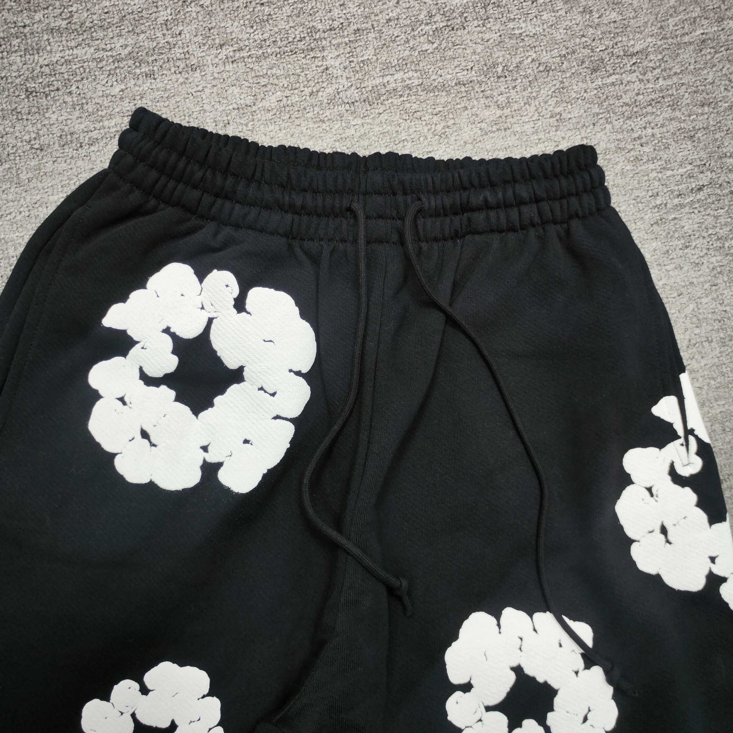 Black Cotton Wreath Sweatpants with all-over white puff print
Close-up of white Cotton Wreath puff print on Black sweatpants
Raised 3D Cotton Wreath puff print texture on Black sweatpants