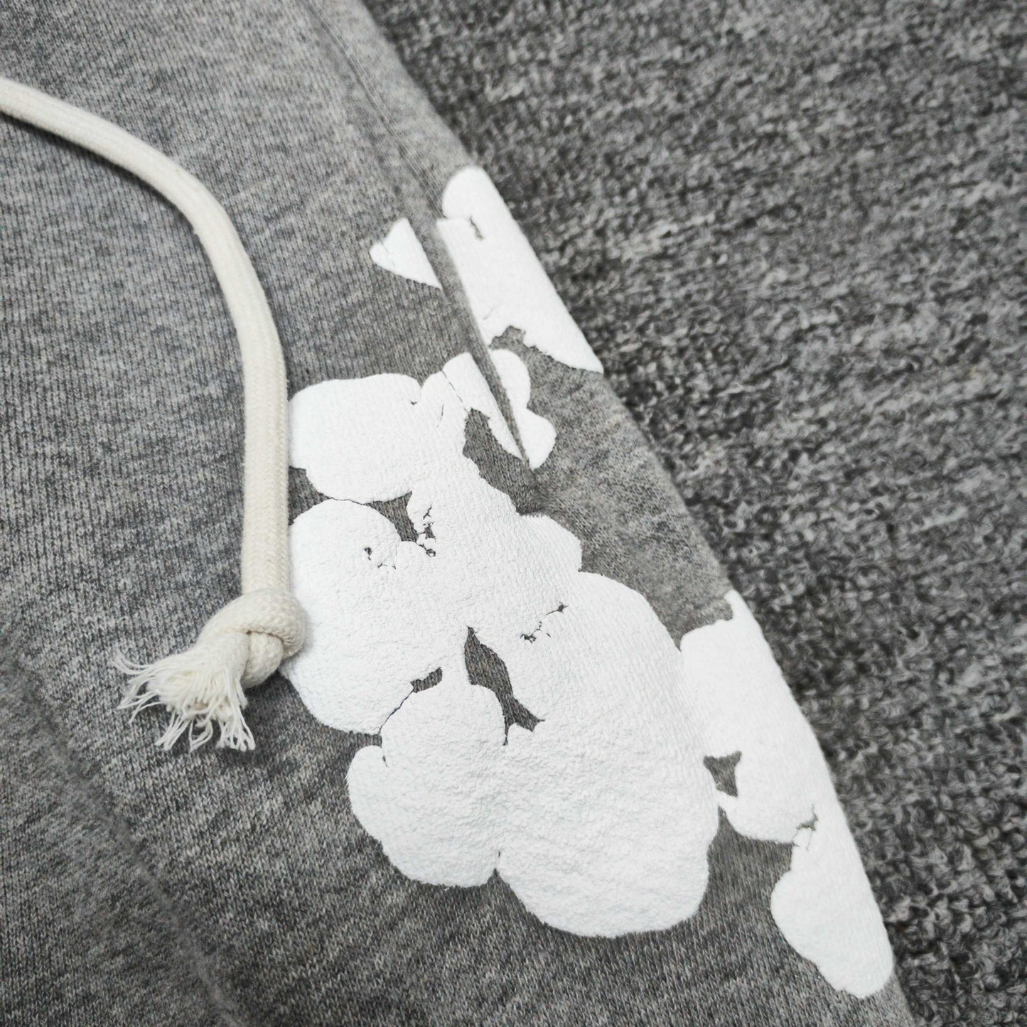 Heather Grey Cotton Wreath Sweatpants with all-over white puff print
Close-up of white Cotton Wreath puff print on Heather Grey sweatpants
Raised 3D Cotton Wreath puff print texture on Heather Grey sweatpants
