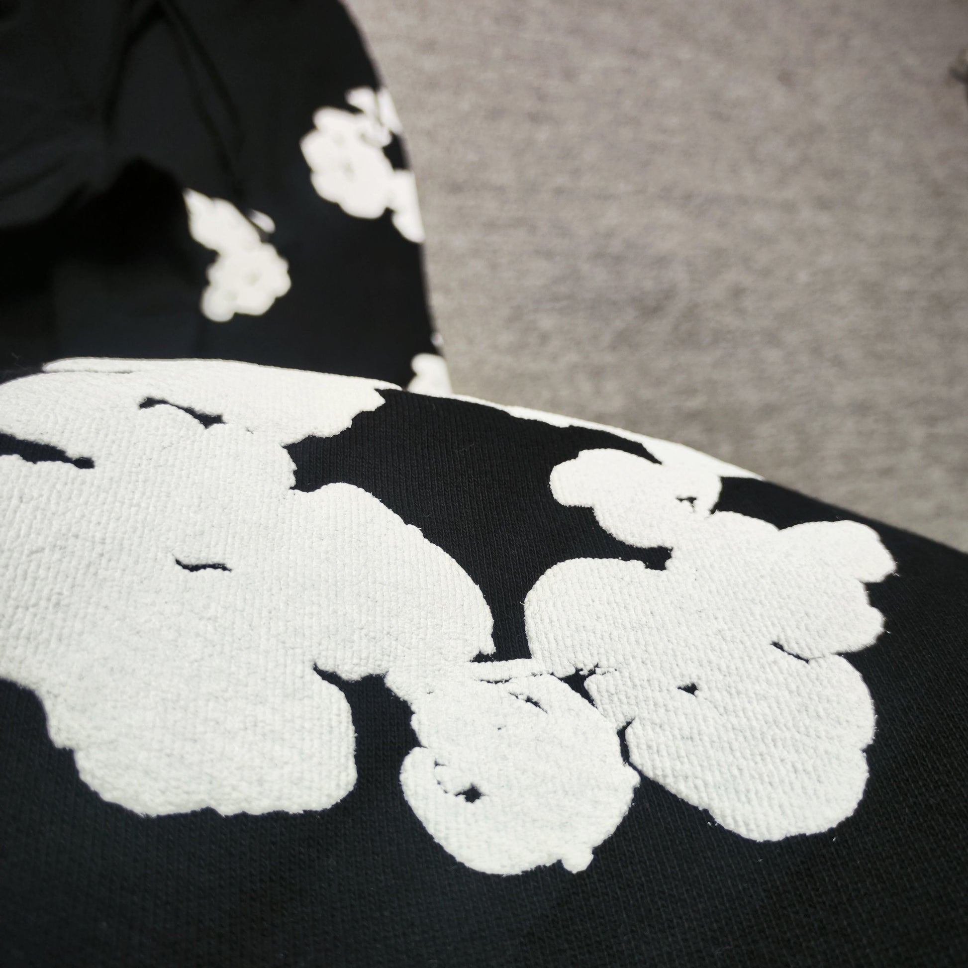 Black Cotton Wreath Sweatpants with all-over white puff print
Close-up of white Cotton Wreath puff print on Black sweatpants
Raised 3D Cotton Wreath puff print texture on Black sweatpants