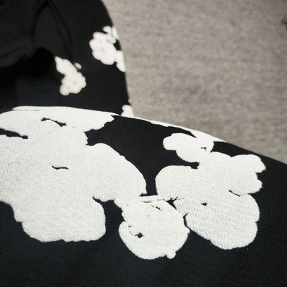 Black Cotton Wreath Sweatpants with all-over white puff print
Close-up of white Cotton Wreath puff print on Black sweatpants
Raised 3D Cotton Wreath puff print texture on Black sweatpants