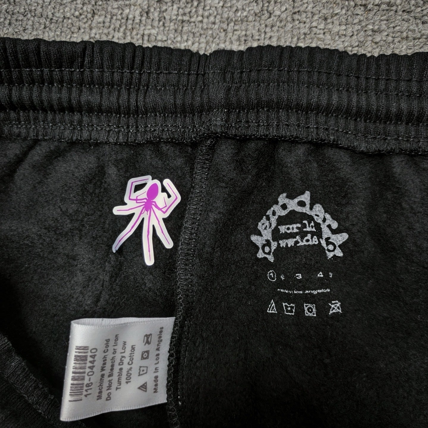 Sp5der P*NK sweatpants inner waistband label detail
Sp5der P*NK sweatpants care label and washing instructions