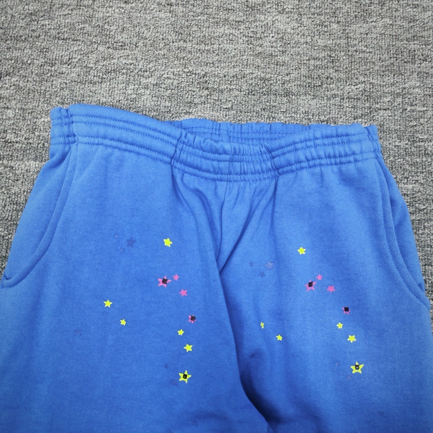 Multicolor star graphic details on SP5DER TC Blue sweatpants