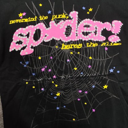 Close-up of raised puff print, pink P*NK lettering and spider web graphic on Sp5der black hoodie