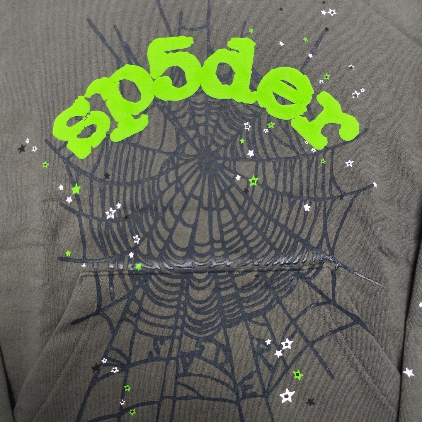 Full puff print artwork on Sp5der Wait Web Hoodie with green logo, dark web and scattered stars
Close-up of electric green puff print lettering on Sp5der Wait Web Hoodie Slate Grey
Side angle showing the raised three-dimensional puff print texture on Sp5der Slate Grey Hoodie