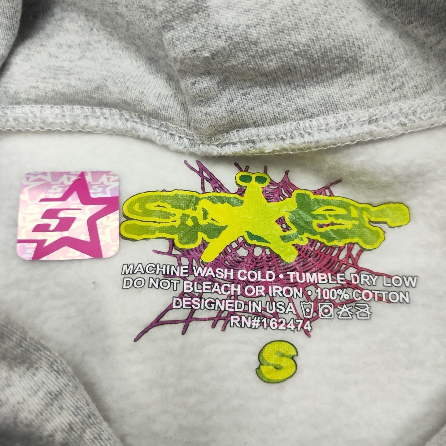 Sp5der Beluga Hoodie Heather Grey neck label and size tag detail
Sp5der Beluga Hoodie Heather Grey care label and washing instruction detail