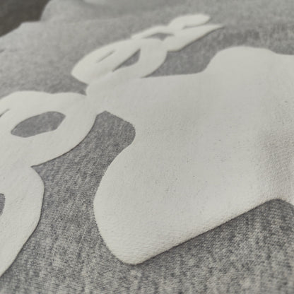 Full white puff-print artwork on Sp5der Beluga Hoodie Heather Grey with oversized logo and stars
Close-up of white puff-print lettering and star graphics on Sp5der Beluga Hoodie Heather Grey
Side angle showing the raised three-dimensional puff-print texture on Sp5der Beluga Hoodie