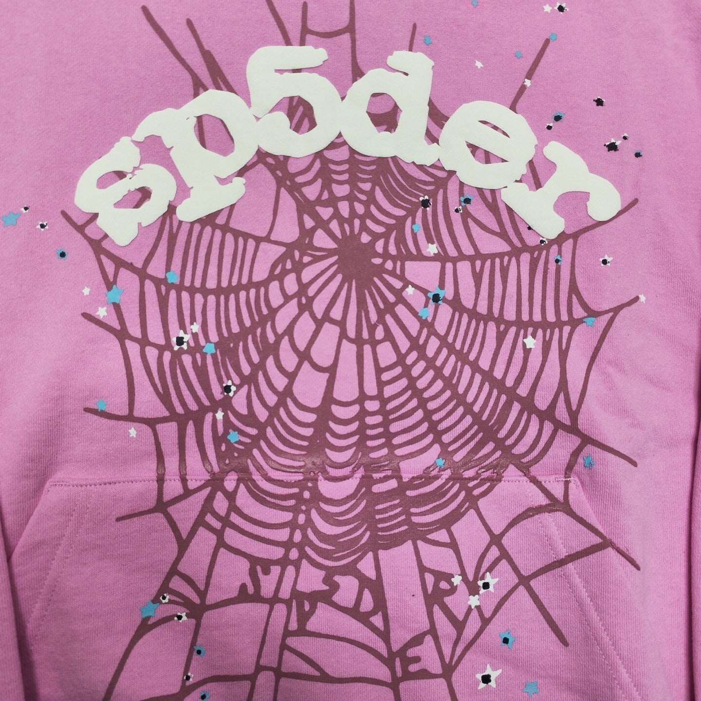 Full puff-print artwork on Sp5der OG Web Hoodie Pink with white logo, spider web and scattered stars
Close-up of raised white Sp5der lettering and star print details on the pink OG Web Hoodie
Side angle showing the raised three-dimensional puff-print texture on Sp5der OG Web Hoodie Pink