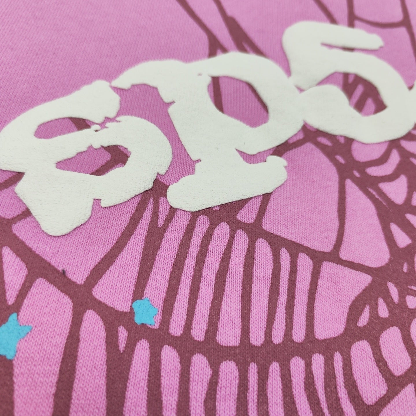 Full puff-print artwork on Sp5der OG Web Hoodie Pink with white logo, spider web and scattered stars
Close-up of raised white Sp5der lettering and star print details on the pink OG Web Hoodie
Side angle showing the raised three-dimensional puff-print texture on Sp5der OG Web Hoodie Pink
