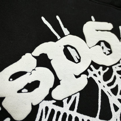 Full white puff-print artwork on Sp5der OG Web Hoodie Black with oversized logo and spider web
Close-up of raised white Sp5der lettering and web print details on the black OG Web Hoodie
Side angle showing the three-dimensional white puff-print texture on Sp5der OG Web Hoodie Black