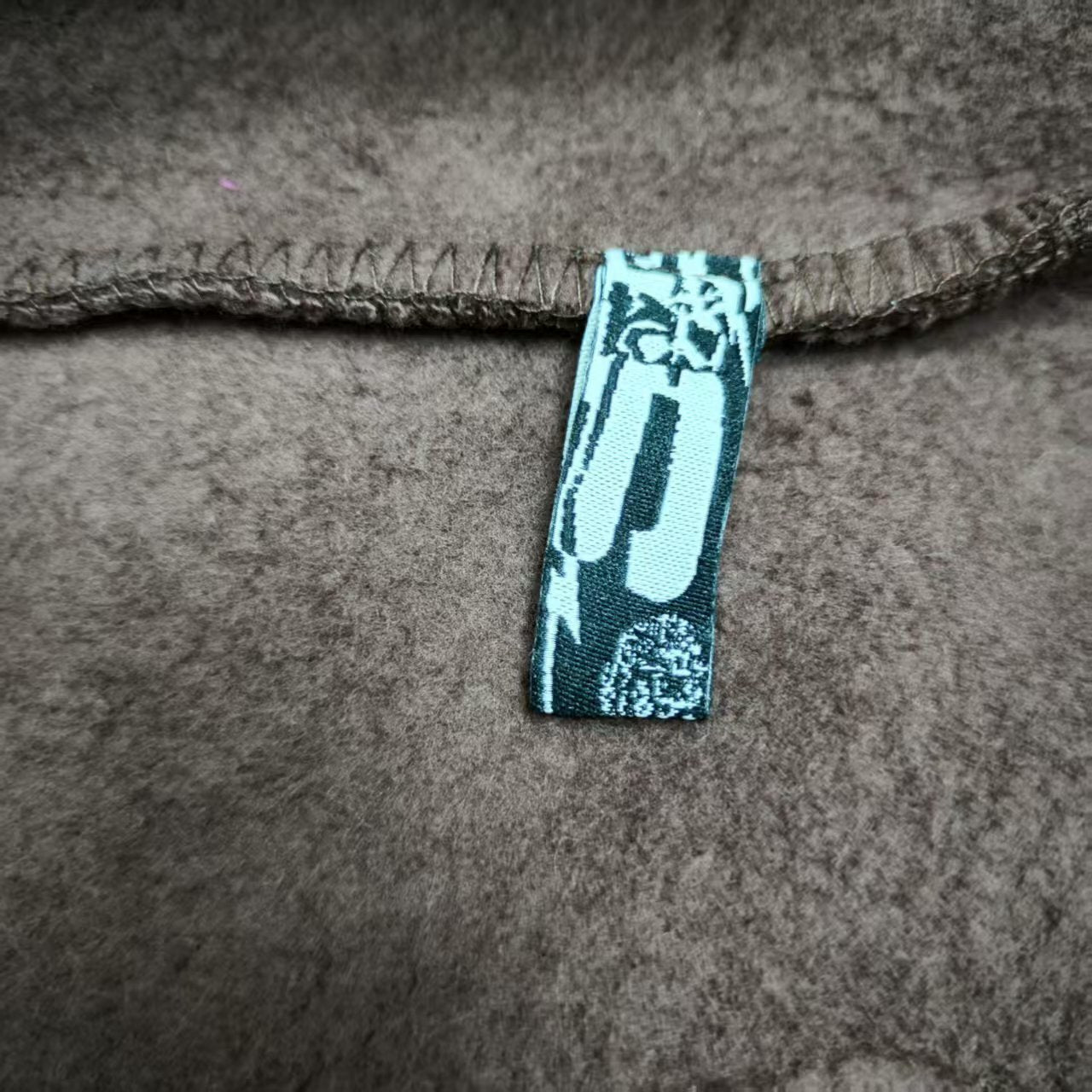 Sp5der Angel Number 555 Hoodie Brown neck label and size tag detail
Sp5der Angel Number 555 Hoodie Brown care label and washing instruction detail