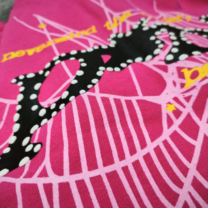 Full graphic artwork on Sp5der P*NK Hoodie Pink with black logo, white web and colorful stars
Close-up of black P*NK lettering with white dot trim on Sp5der Pink Hoodie
Side angle showing the raised three-dimensional graphic texture on Sp5der P*NK Hoodie Pink