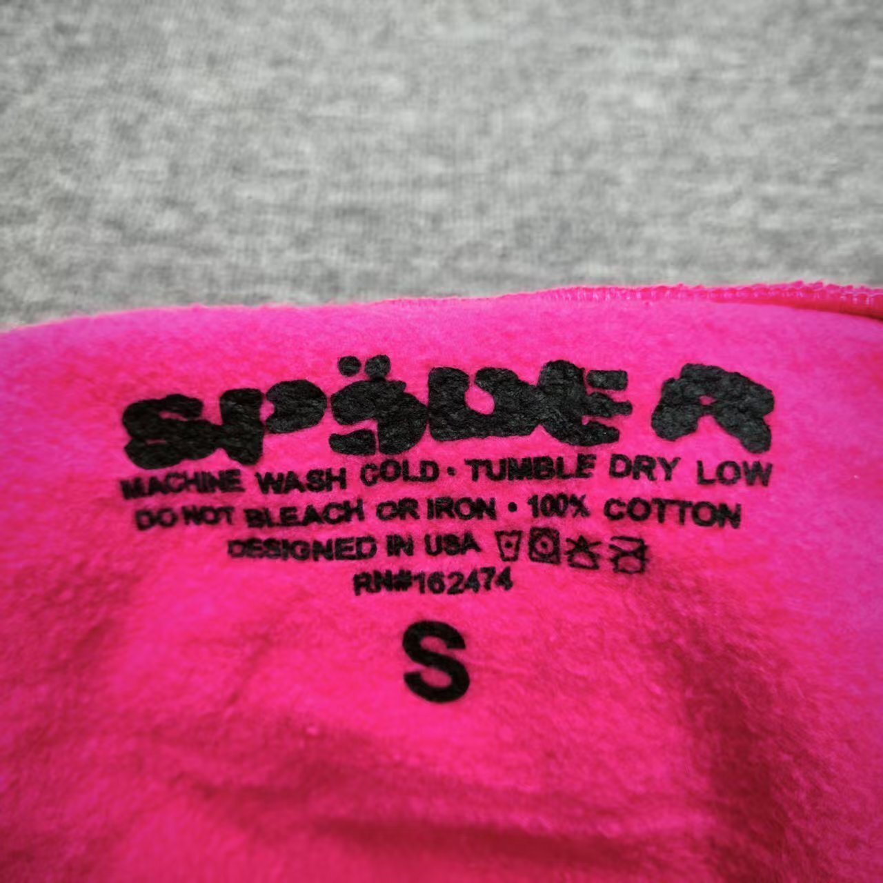 Sp5der P*NK Hoodie Pink neck label and size tag detail
Sp5der P*NK Hoodie Pink care label and washing instruction detail