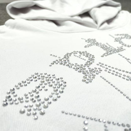 Full rhinestone artwork on Sp5der OG Logo Hoodie White with crystal lettering and spider web
Close-up of silver rhinestone Sp5der lettering and crystal web details on the white hoodie
Side angle showing the raised three-dimensional rhinestone texture on Sp5der White Hoodie