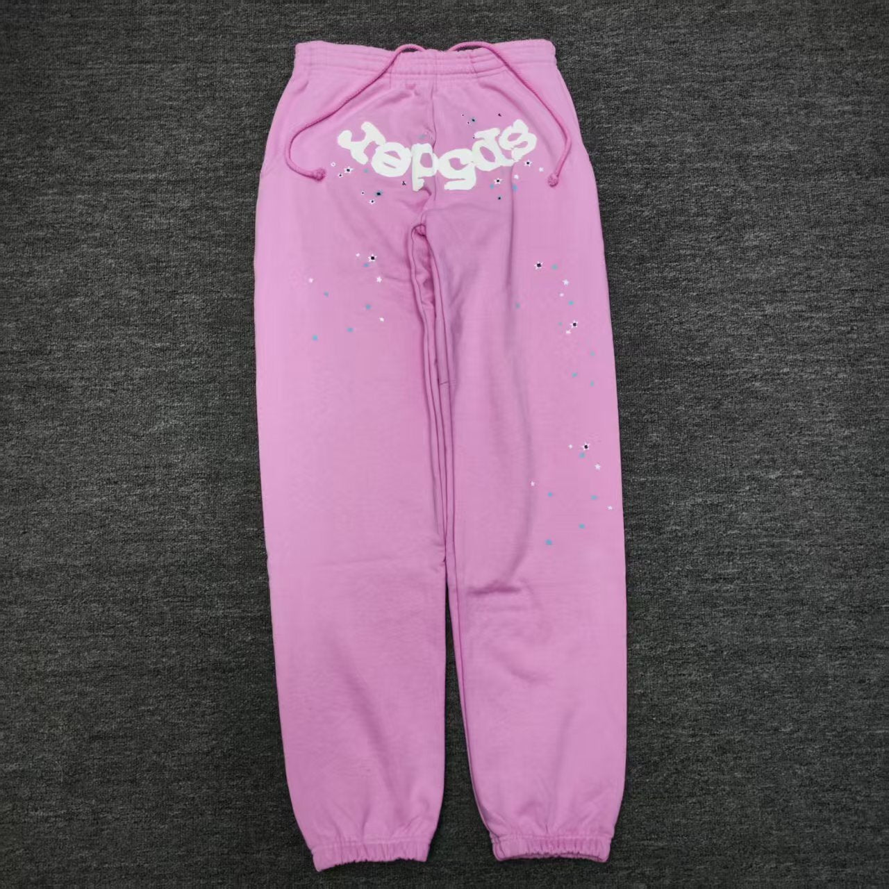 SP5DER Atlanta pink sweatpants front view with white logo and scattered star graphics
