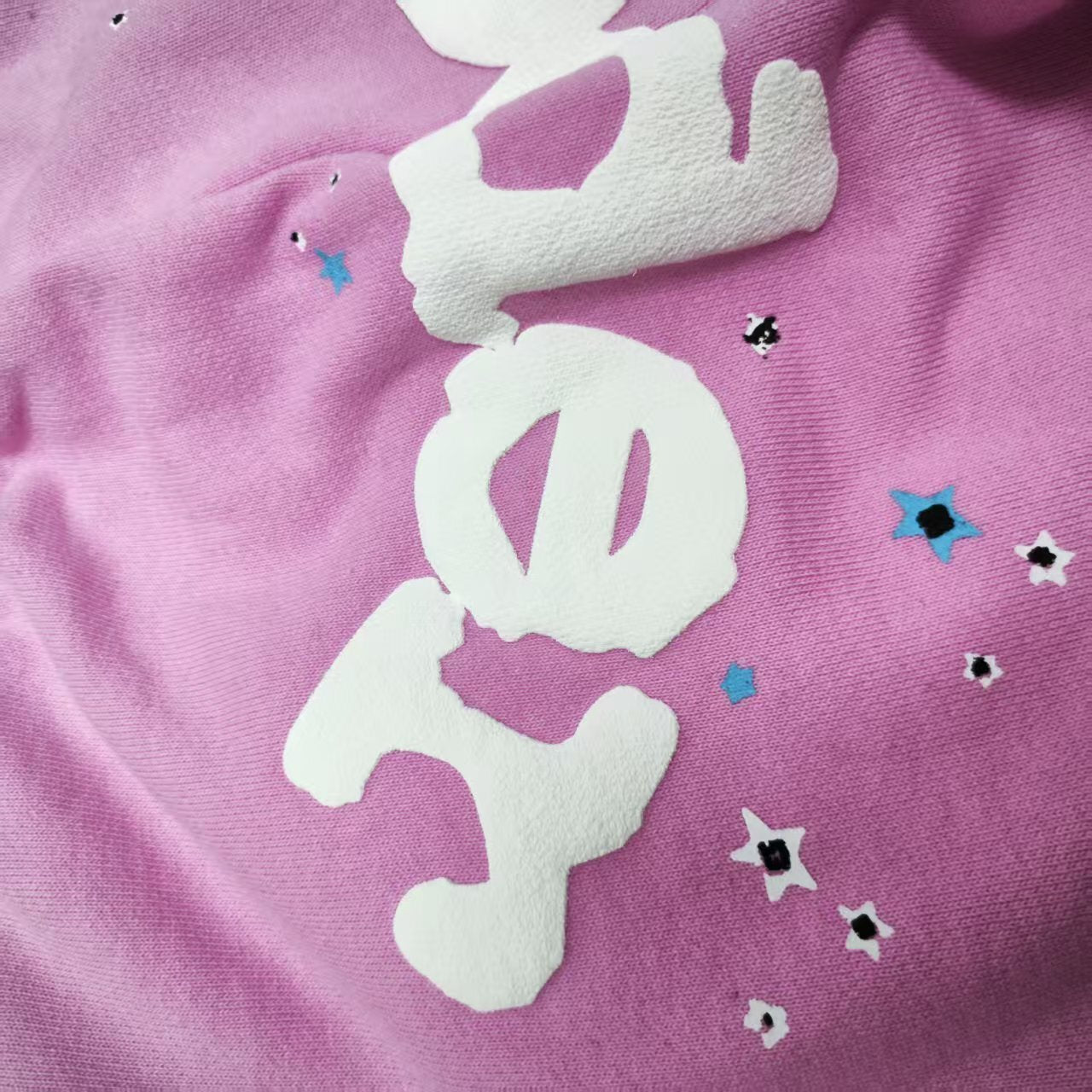 Close-up of raised white SP5DER puff-print logo on pink Atlanta sweatpants
Raised puff-print texture detail on SP5DER Atlanta pink sweatpants