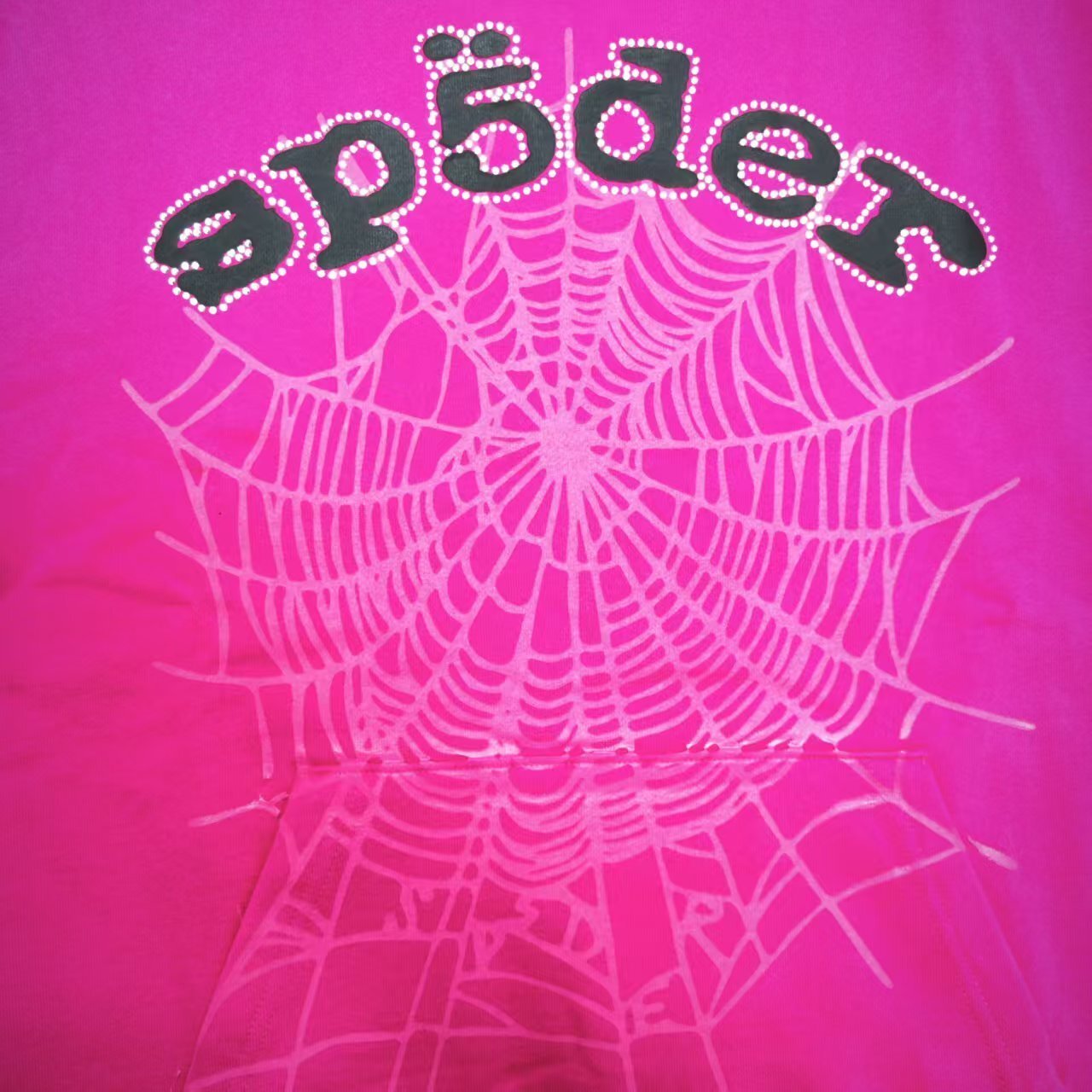 Full front artwork on Sp5der Legacy Hoodie Pink White with puff lettering, rhinestones and spider web
Close-up of raised black SP5DER puff-print lettering on the pink Legacy Hoodie
Close-up of rhinestone trim surrounding the black SP5DER lettering on the pink Legacy Hoodie
Side angle showing raised puff lettering and three-dimensional rhinestone details on Sp5der Legacy Hoodie