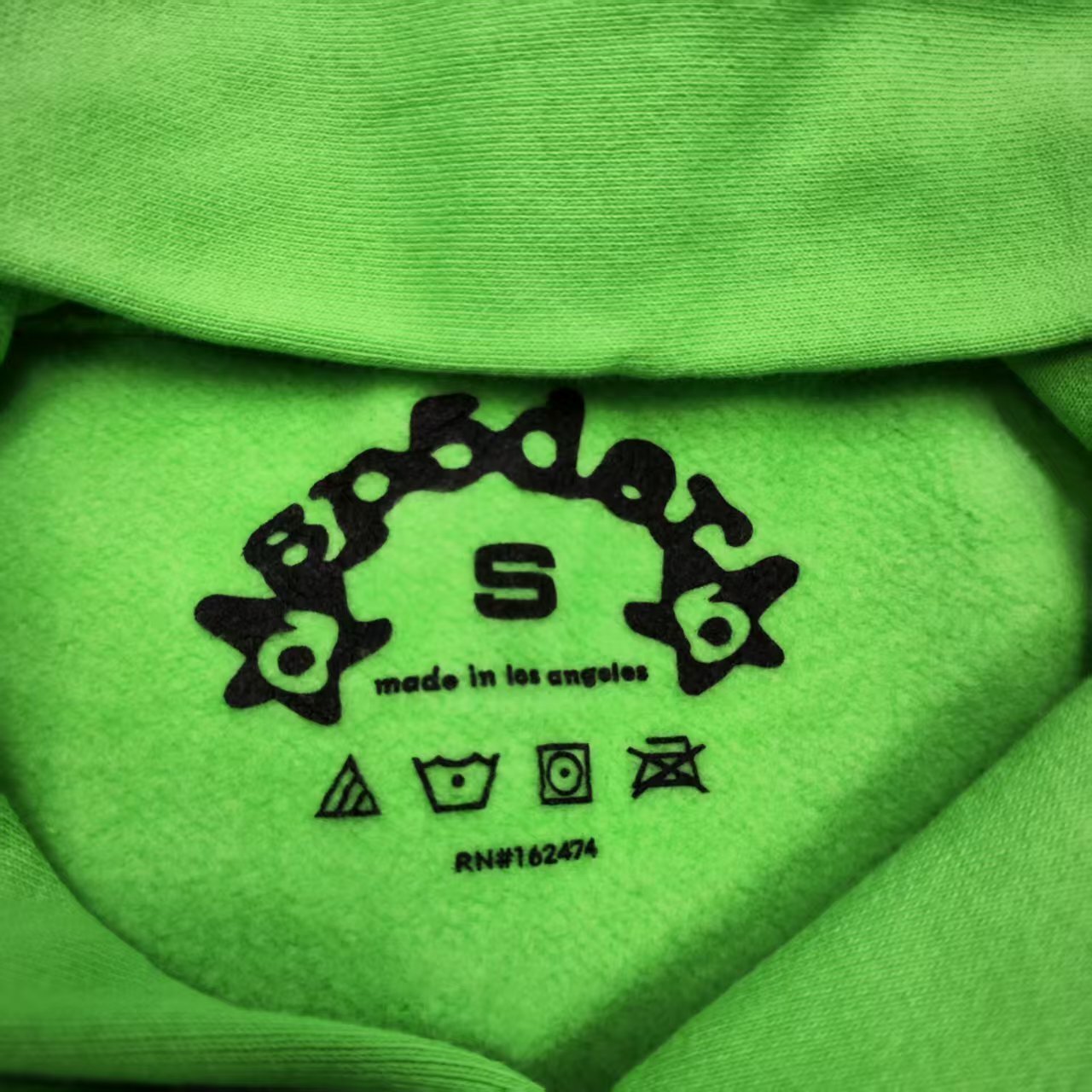 Sp5der Web Hoodie Slime Green neck label and size tag detail
Sp5der Web Hoodie Slime Green care label and washing instruction detail
