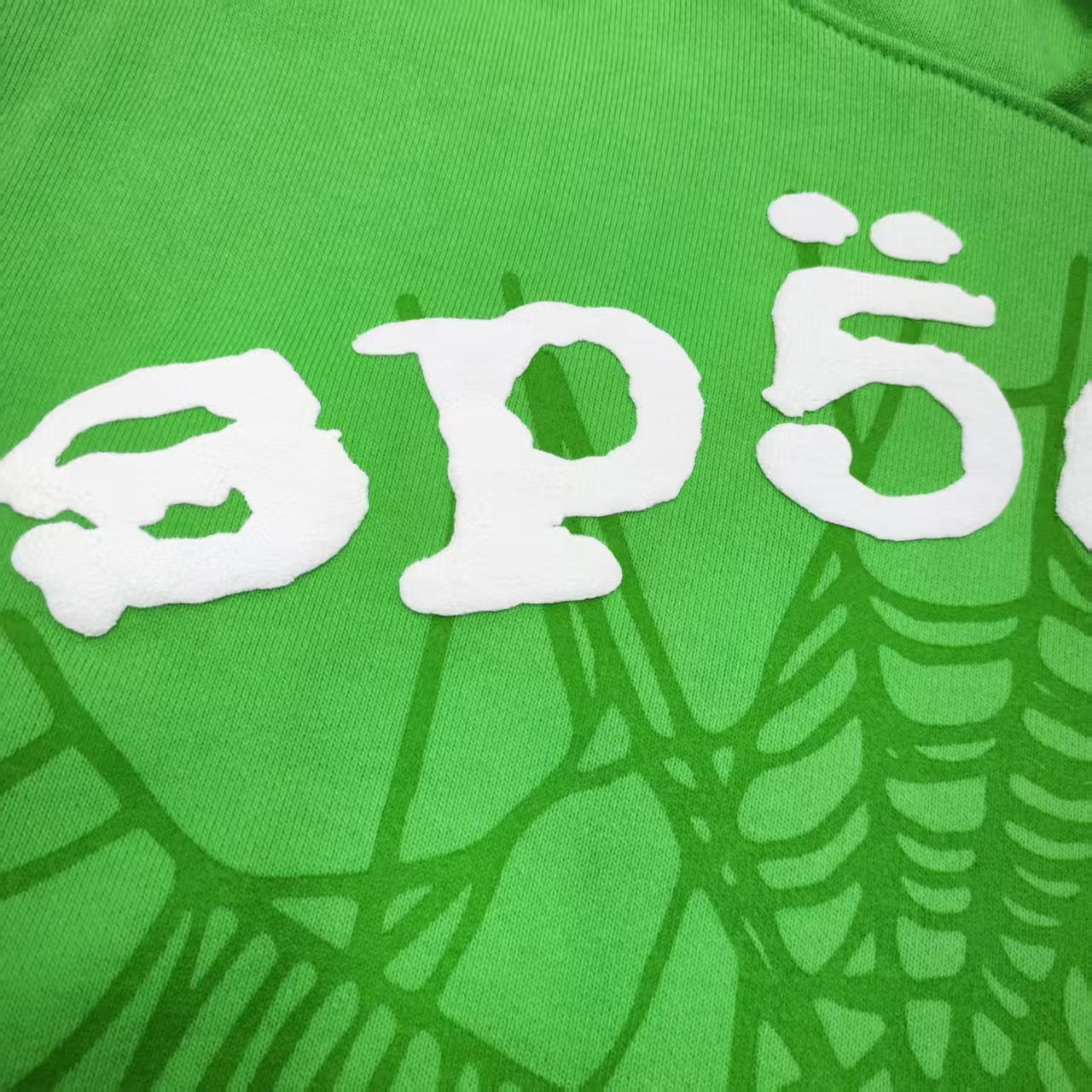 Full front artwork on Sp5der Web Hoodie Slime Green with white puff lettering and tonal web graphic
Close-up of raised white Sp5der puff-print lettering on the Slime Green Web Hoodie
Side angle showing the three-dimensional white puff-print texture on Sp5der Slime Green Hoodie