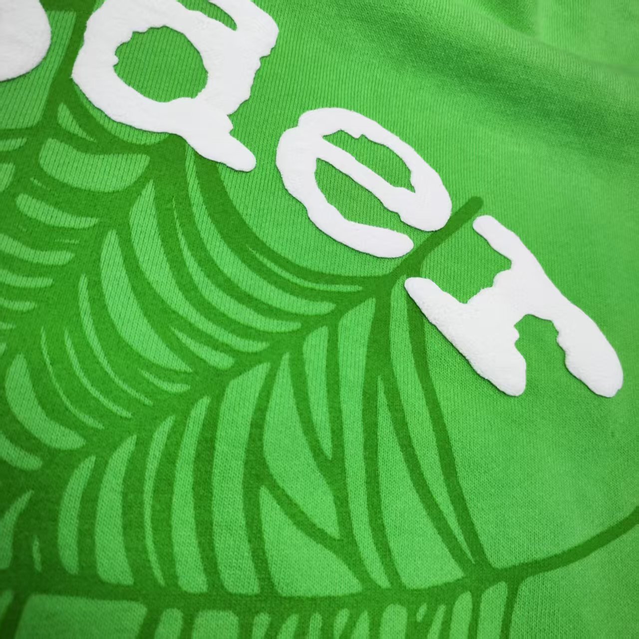 Full front artwork on Sp5der Web Hoodie Slime Green with white puff lettering and tonal web graphic
Close-up of raised white Sp5der puff-print lettering on the Slime Green Web Hoodie
Side angle showing the three-dimensional white puff-print texture on Sp5der Slime Green Hoodie