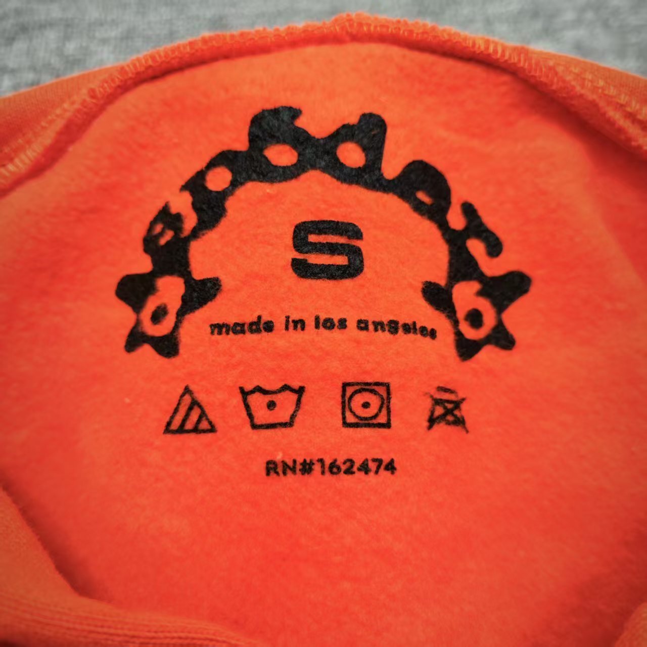 Sp5der Logo Hoodie Sweatshirt Orange neck label and size tag detail
Sp5der Logo Hoodie Sweatshirt Orange care label and washing instruction detail