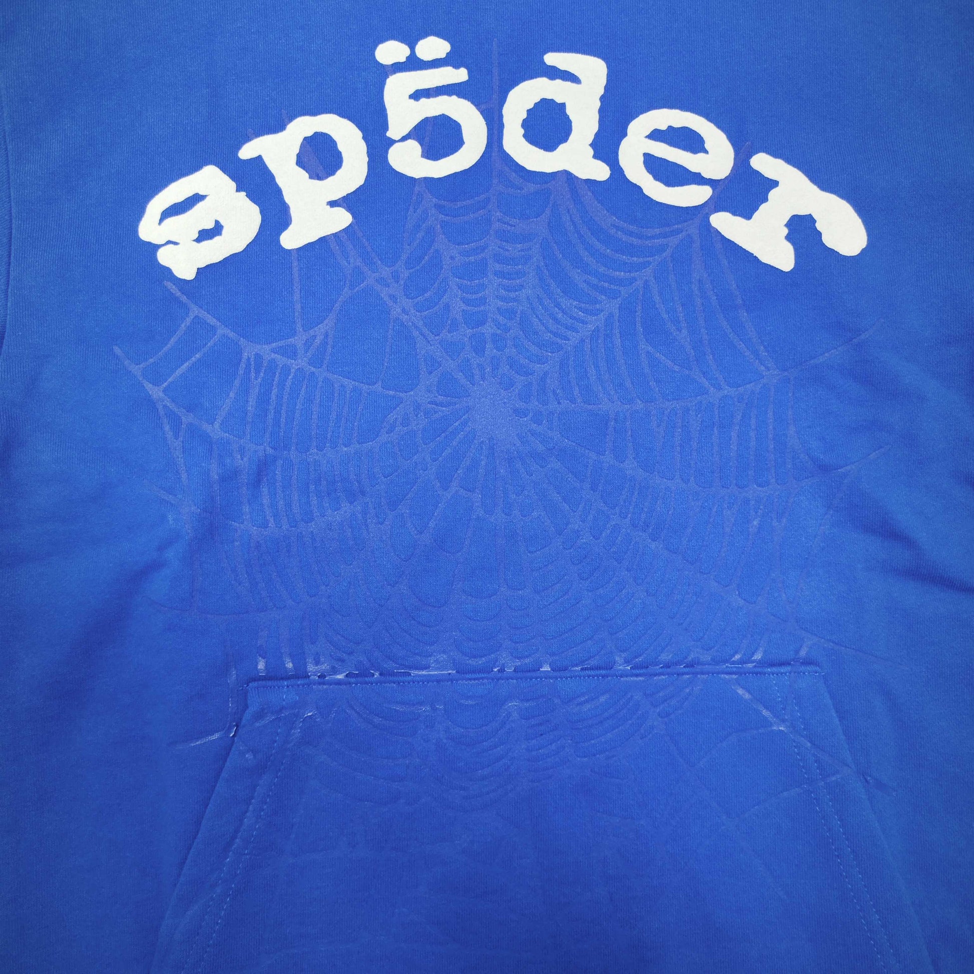 Full front artwork on Sp5der Logo Hoodie Blue with raised white logo and tonal web graphic
Close-up of raised white Sp5der lettering on the Blue Logo Hoodie
Side angle showing the three-dimensional raised white logo detail on Sp5der Blue Hoodie
Close-up of tonal spider-web artwork across the front of Sp5der Logo Hoodie Blue