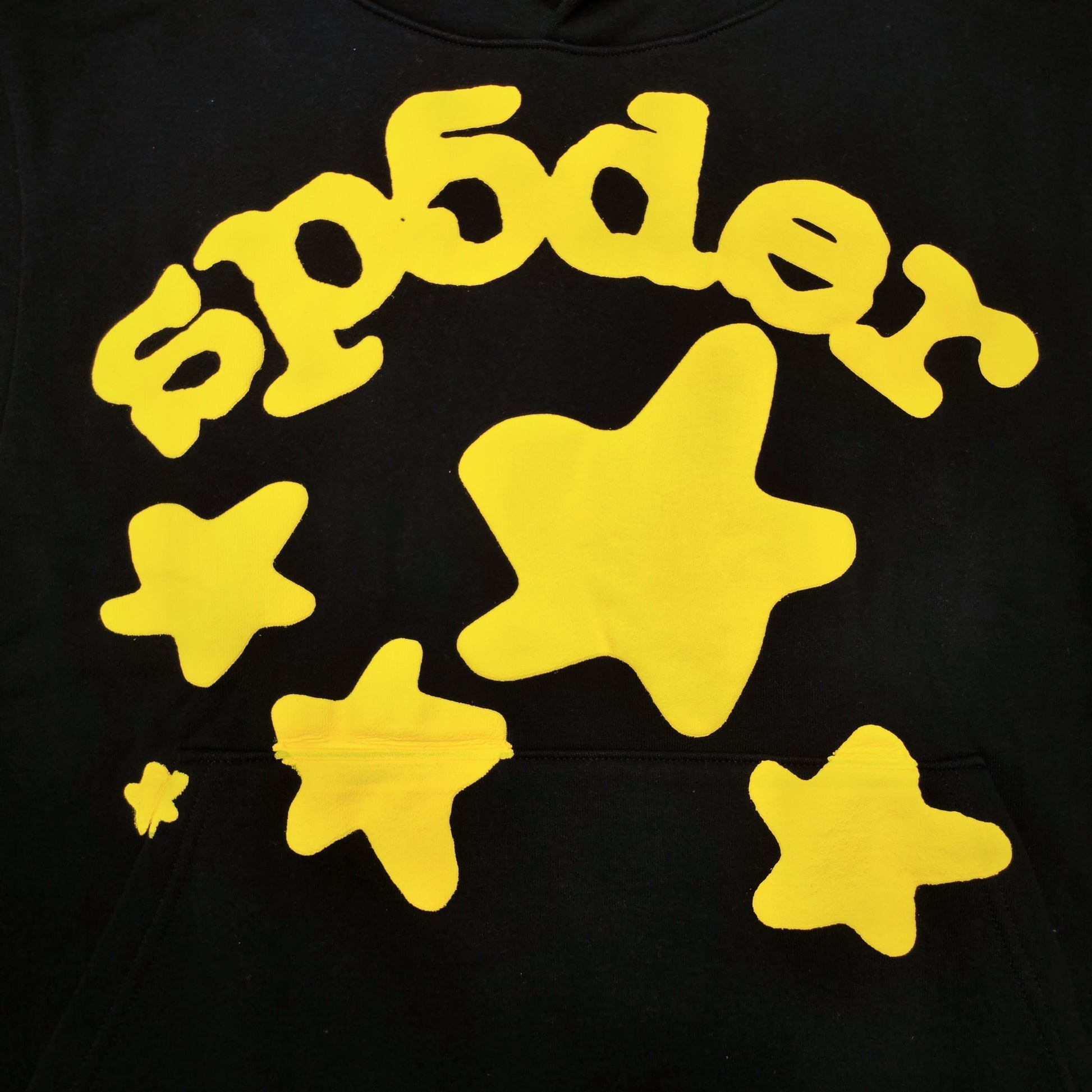 Full yellow puff-print artwork on Sp5der Beluga Hoodie Onyx Yellow with logo and star graphics
Close-up of raised yellow Sp5der lettering and smooth puff-print edges on the black Beluga Hoodie
Side angle showing the three-dimensional yellow puff-print texture on Sp5der Beluga Hoodie
Yellow star and number graphics printed across the sleeve of Sp5der Beluga Hoodie Onyx Yellow