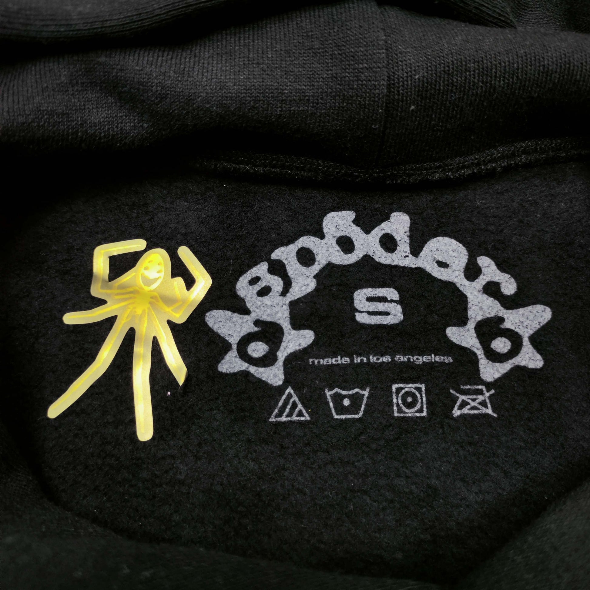 Sp5der Beluga Hoodie Onyx Yellow neck label and size tag detail
Sp5der Beluga Hoodie Onyx Yellow care label and washing instruction detail