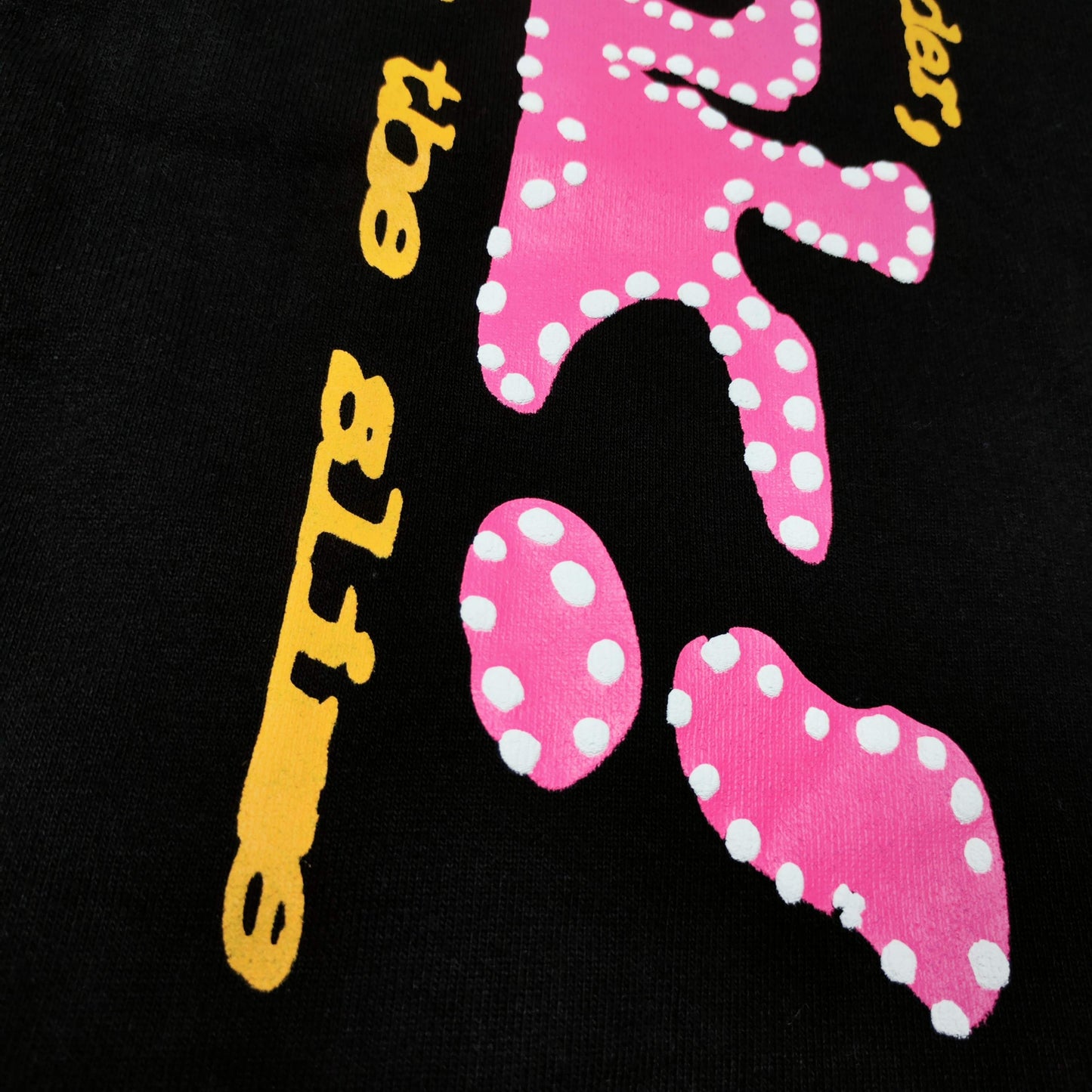 Close-up of pink SP5DER puff-print graphic on black P*NK V2 sweatpants
Raised pink puff-print texture on SP5DER P*NK V2 black sweatpants
Close-up of defined puff-print edges on SP5DER P*NK V2 sweatpants
Yellow slogan print detail on SP5DER P*NK V2 black sweatpants