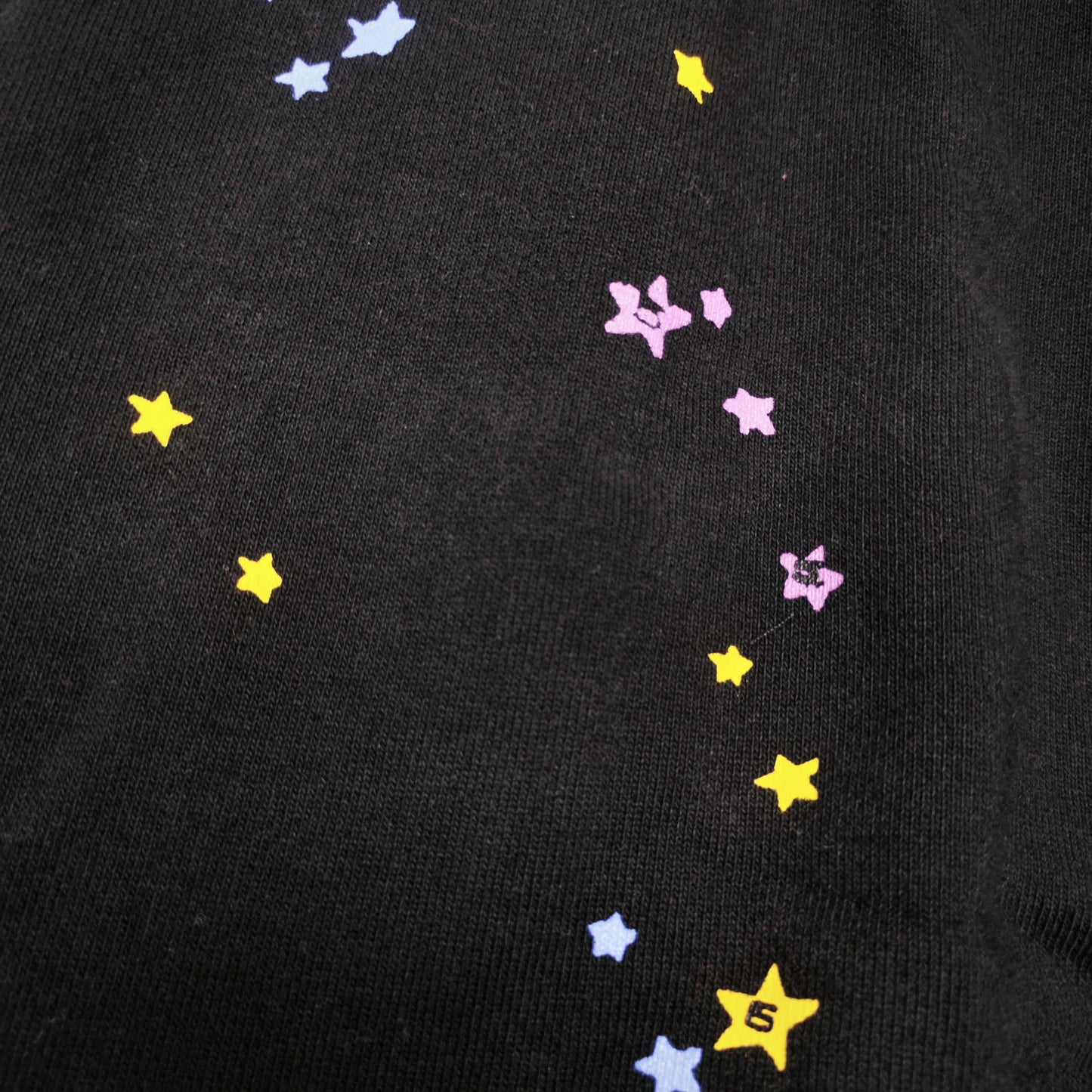 Close-up of pink SP5DER puff-print graphic on black P*NK V2 sweatpants
Raised pink puff-print texture on SP5DER P*NK V2 black sweatpants
Close-up of defined puff-print edges on SP5DER P*NK V2 sweatpants
Yellow slogan print detail on SP5DER P*NK V2 black sweatpants