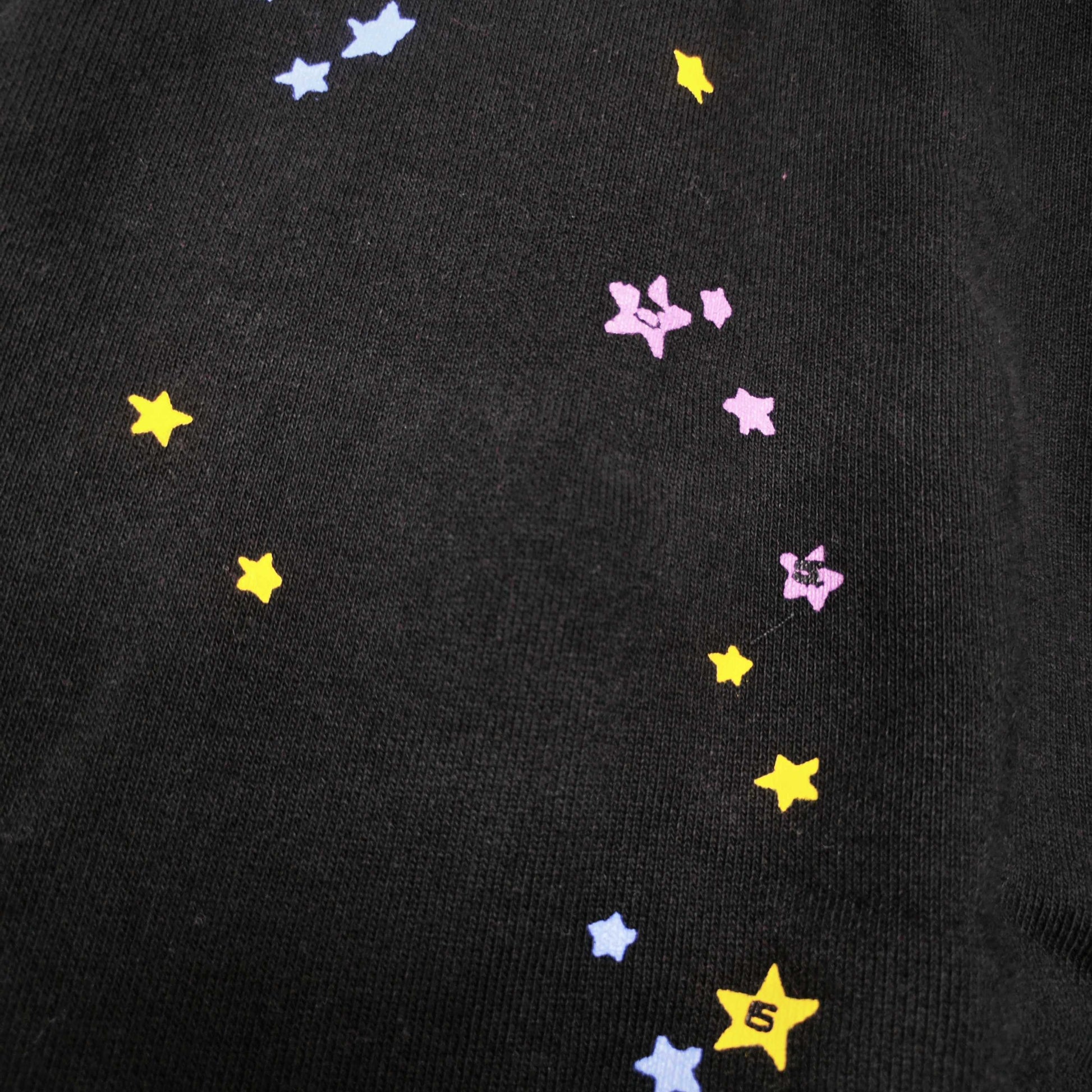Close-up of pink SP5DER puff-print graphic on black P*NK V2 sweatpants
Raised pink puff-print texture on SP5DER P*NK V2 black sweatpants
Close-up of defined puff-print edges on SP5DER P*NK V2 sweatpants
Yellow slogan print detail on SP5DER P*NK V2 black sweatpants