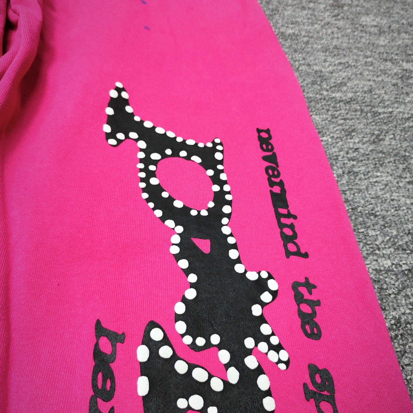 Close-up of black SP5DER puff-print graphic on pink P*NK V2 sweatpants
Raised black puff-print texture on SP5DER P*NK V2 pink sweatpants