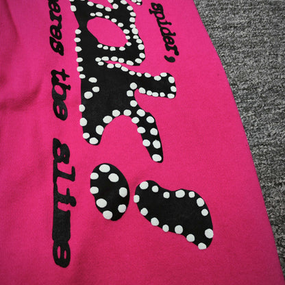 Close-up of black SP5DER puff-print graphic on pink P*NK V2 sweatpants
