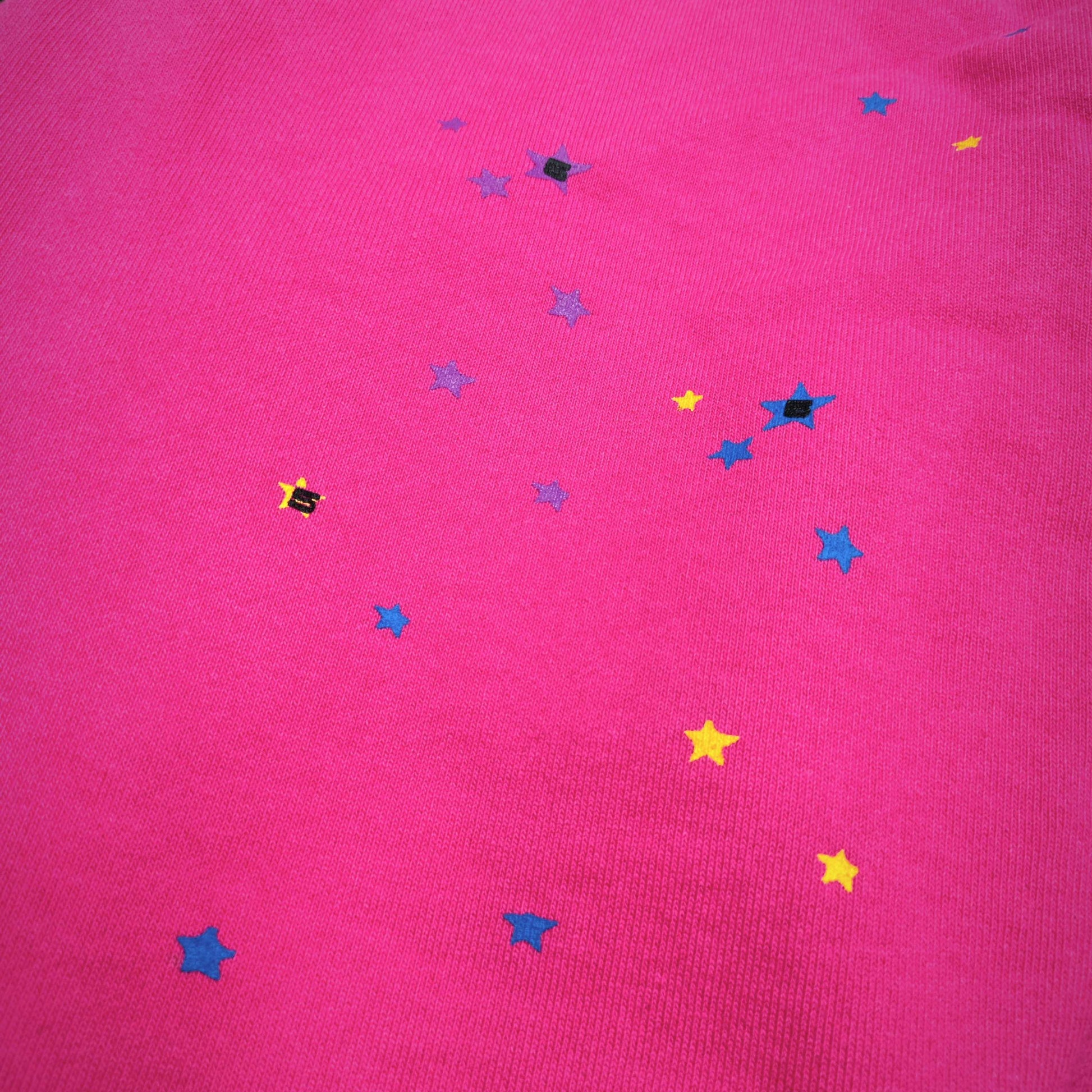 Scattered multicolor star graphics on SP5DER P*NK V2 pink sweatpants