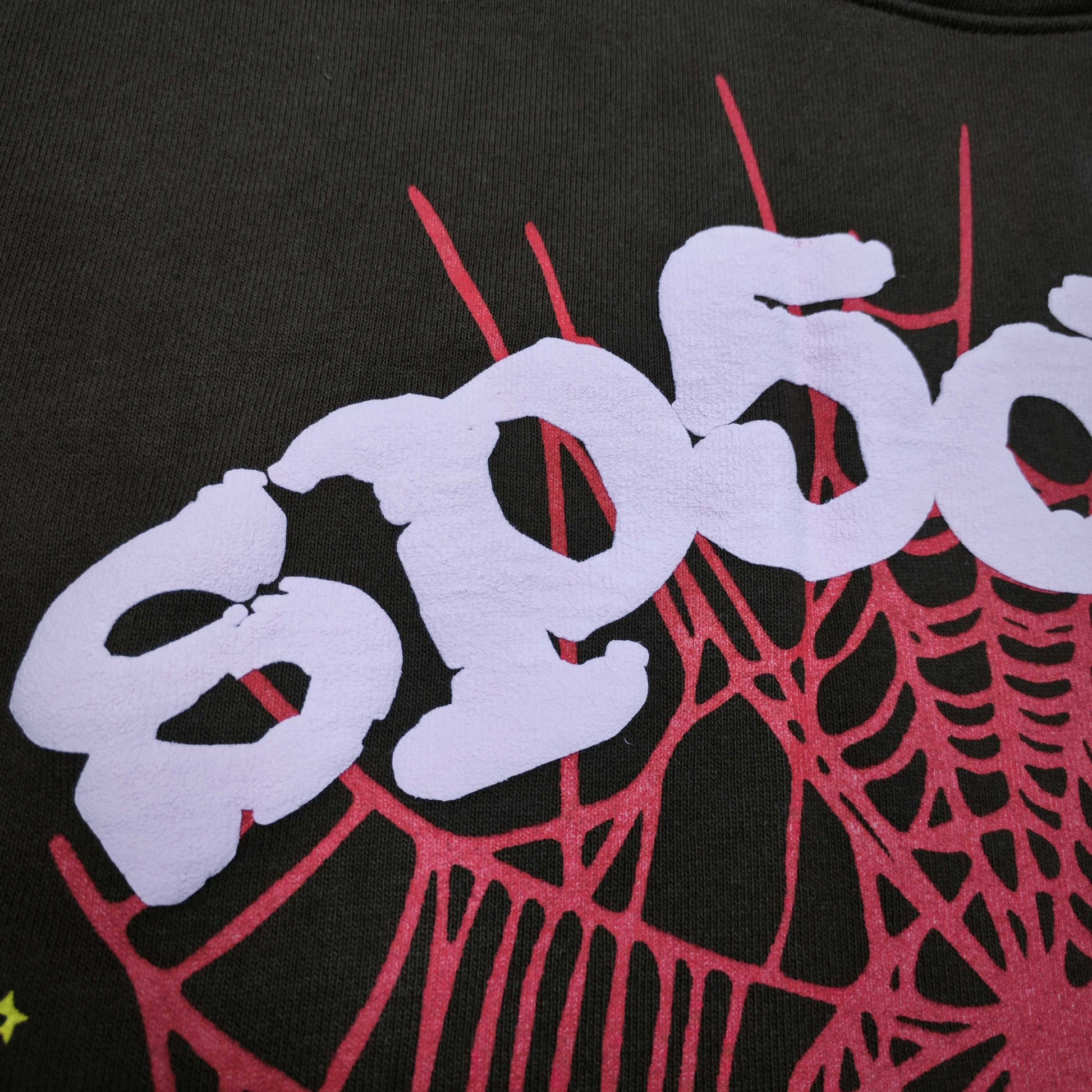 Full front artwork on Sp5der Web Hoodie Brown with pink puff logo, red web and yellow stars
Close-up of raised pink Sp5der puff-print lettering on the Brown Web Hoodie
Side angle showing the three-dimensional pink puff-print texture on Sp5der Web Hoodie Brown
Close-up of red spider-web artwork and yellow star details on Sp5der Web Hoodie Brown