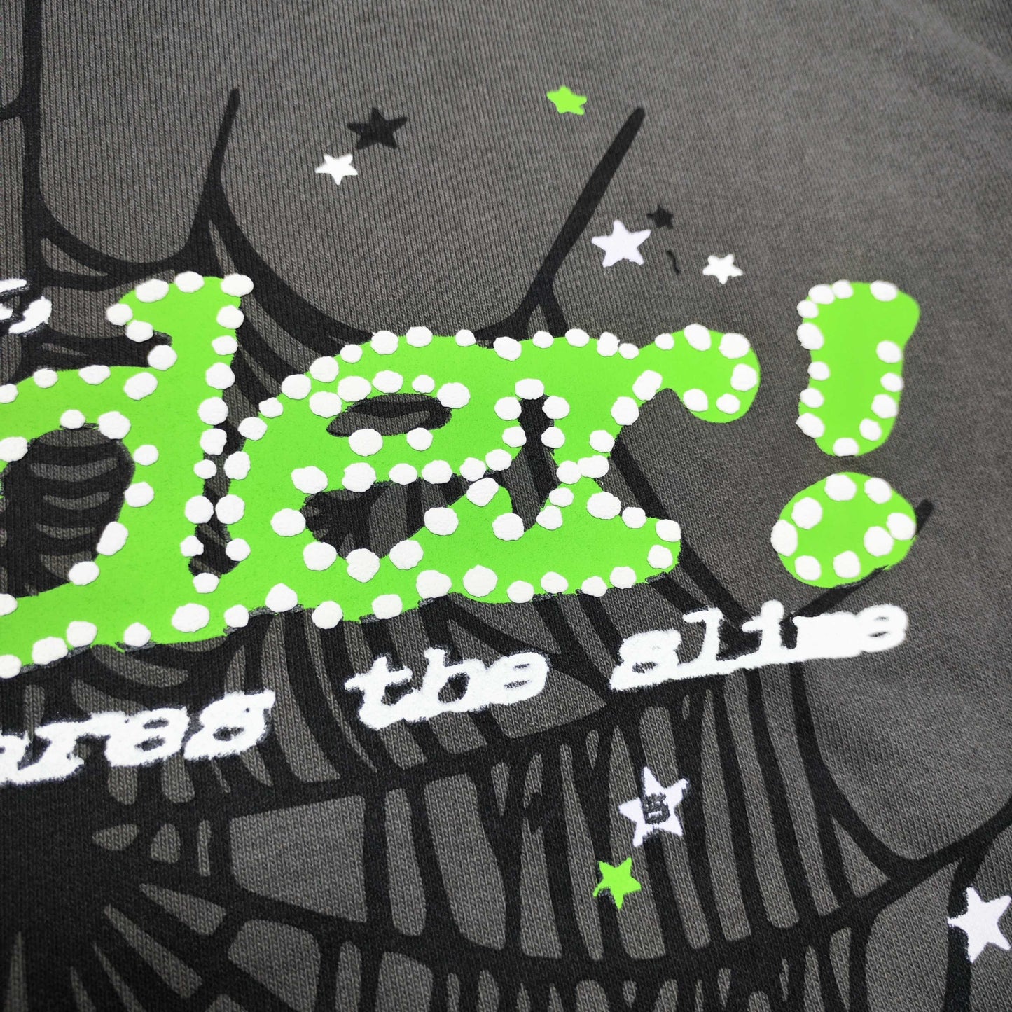 Full front artwork on Sp5der Punk V2 Hoodie Slate Grey with green puff logo and black spider web
Close-up of neon-green SP5DER puff-print lettering with white dot details on the Slate Grey Hoodie
Side angle showing the three-dimensional neon-green puff-print texture on Sp5der Punk V2 Hoodie
Close-up of black spider-web artwork on the front of Sp5der Punk V2 Hoodie Slate Grey