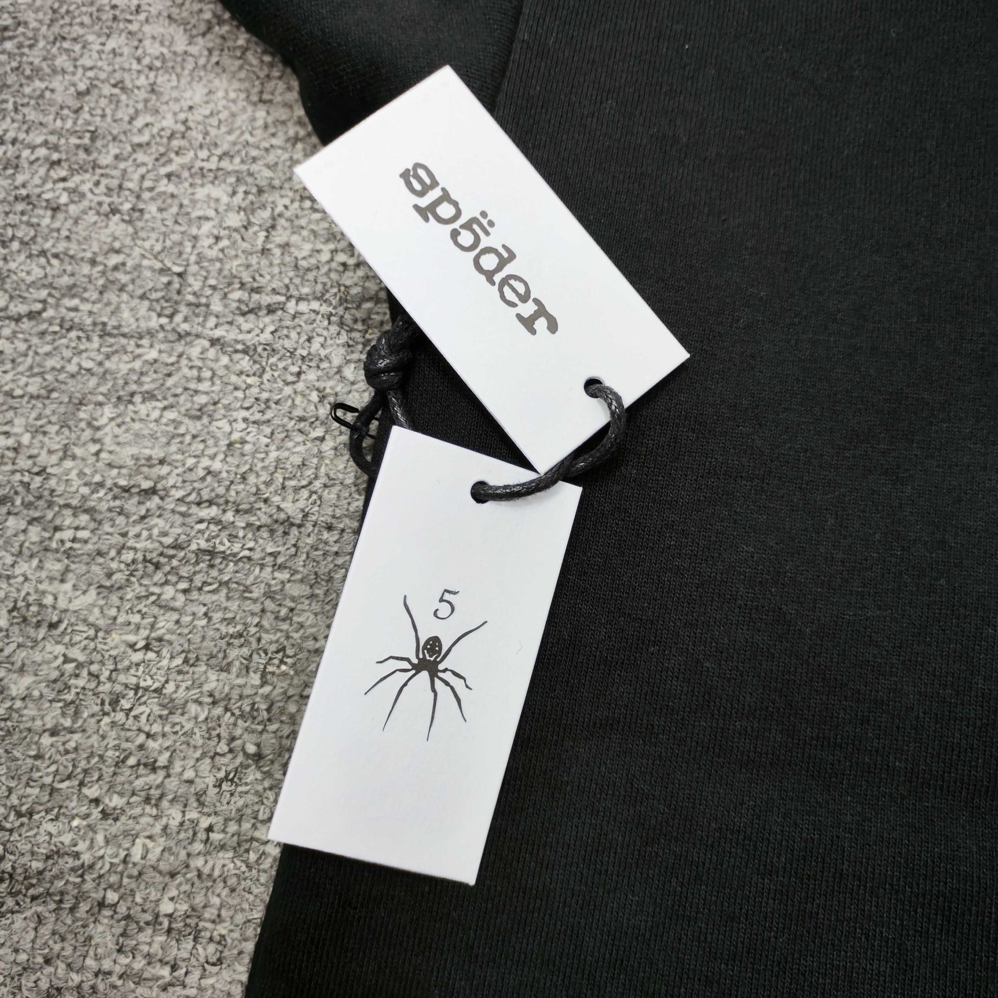 Sp5der Angel Number Hoodie Black neck label and size tag detail
Sp5der Angel Number Hoodie Black care label and washing instruction detail