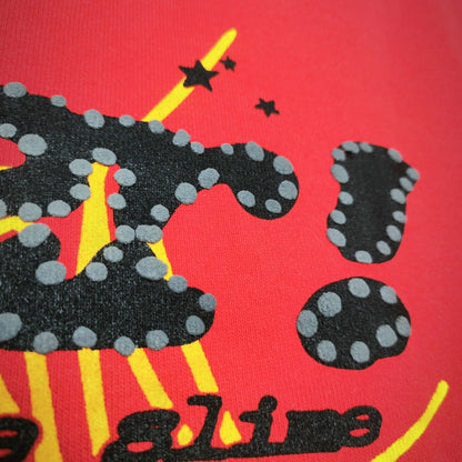 Full front artwork on Sp5der P*NK V2 Hoodie Red with black puff logo, yellow web and stars
Close-up of raised black SP5DER puff-print lettering with dotted details on the red hoodie
Side angle showing the three-dimensional black puff-print texture on Sp5der P*NK V2 Hoodie Red
Close-up of yellow spider-web artwork and black star details on Sp5der P*NK V2 Hoodie Red