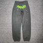 SP5DER Wait Web slate grey sweatpants front view with neon green logo and scattered stars
