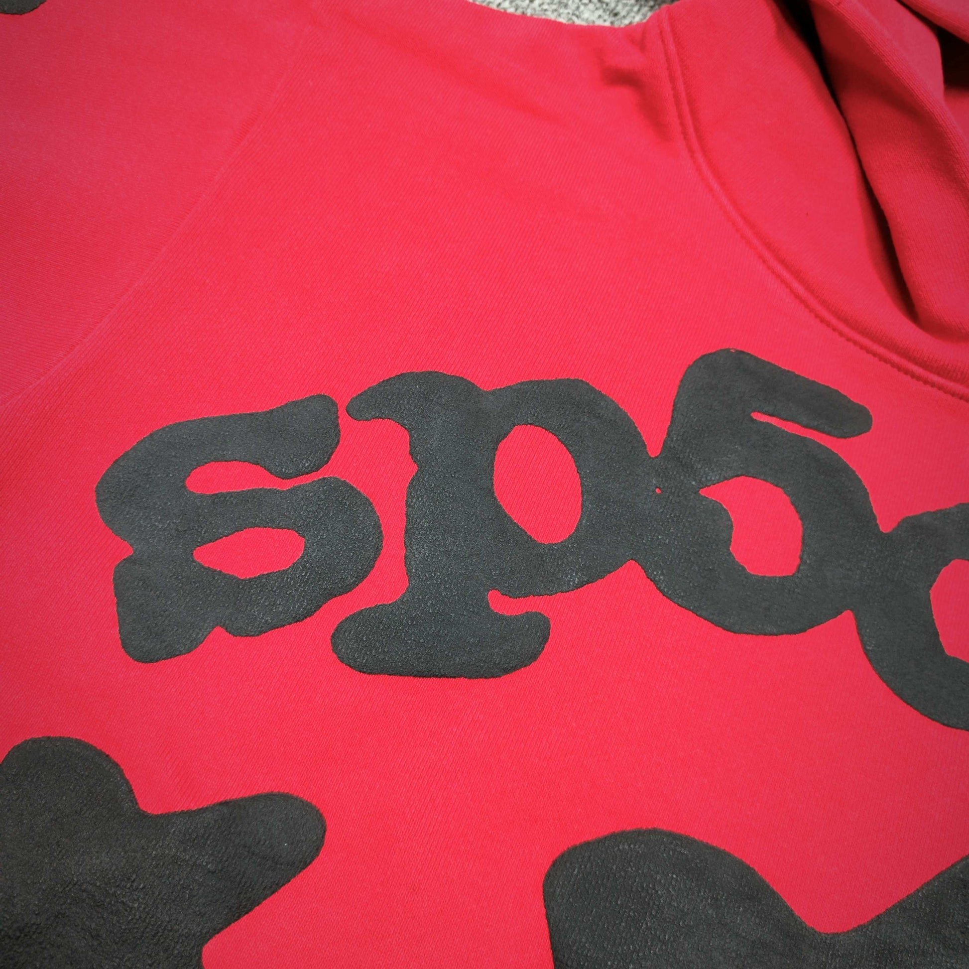 Full black puff-print artwork on Sp5der Beluga Hoodie Red Black with logo, stars and number graphics
Full black puff-print artwork on Sp5der Beluga Hoodie Red Black with logo, stars and number graphics
Full black puff-print artwork on Sp5der Beluga Hoodie Red Black with logo, stars and number graphics
Black star and number graphics printed across the sleeve of Sp5der Beluga Hoodie Red Black