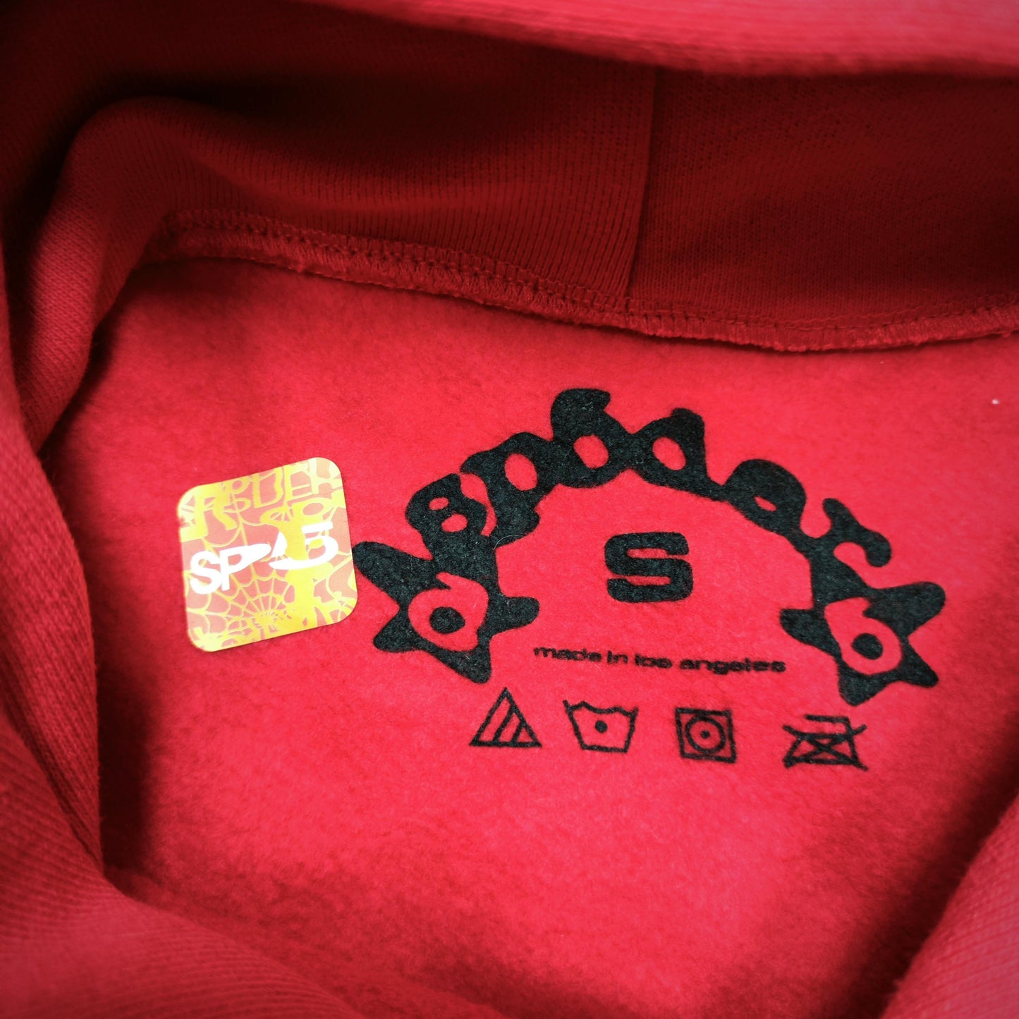 Sp5der Beluga Hoodie Red Black neck label and size tag detail
Sp5der Beluga Hoodie Red Black neck label and size tag detail