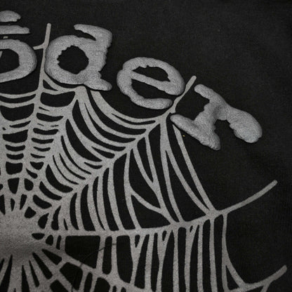 Full front artwork on Sp5der OG Web Hoodie Black with raised grey logo and tonal spider web
Close-up of raised dark-grey SP5DER lettering on the black OG Web Hoodie
Side angle showing the three-dimensional raised logo texture on Sp5der OG Web Hoodie Black
Close-up of tonal dark-grey spider-web artwork on Sp5der OG Web Hoodie Black
Close-up of tonal web graphic alignment around the kangaroo pocket on Sp5der black hoodie